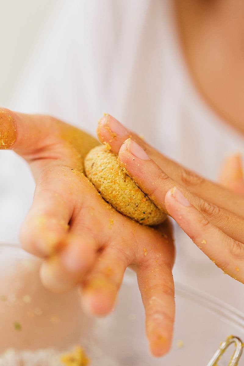 Hands shaping falafel mixture into a small patty.