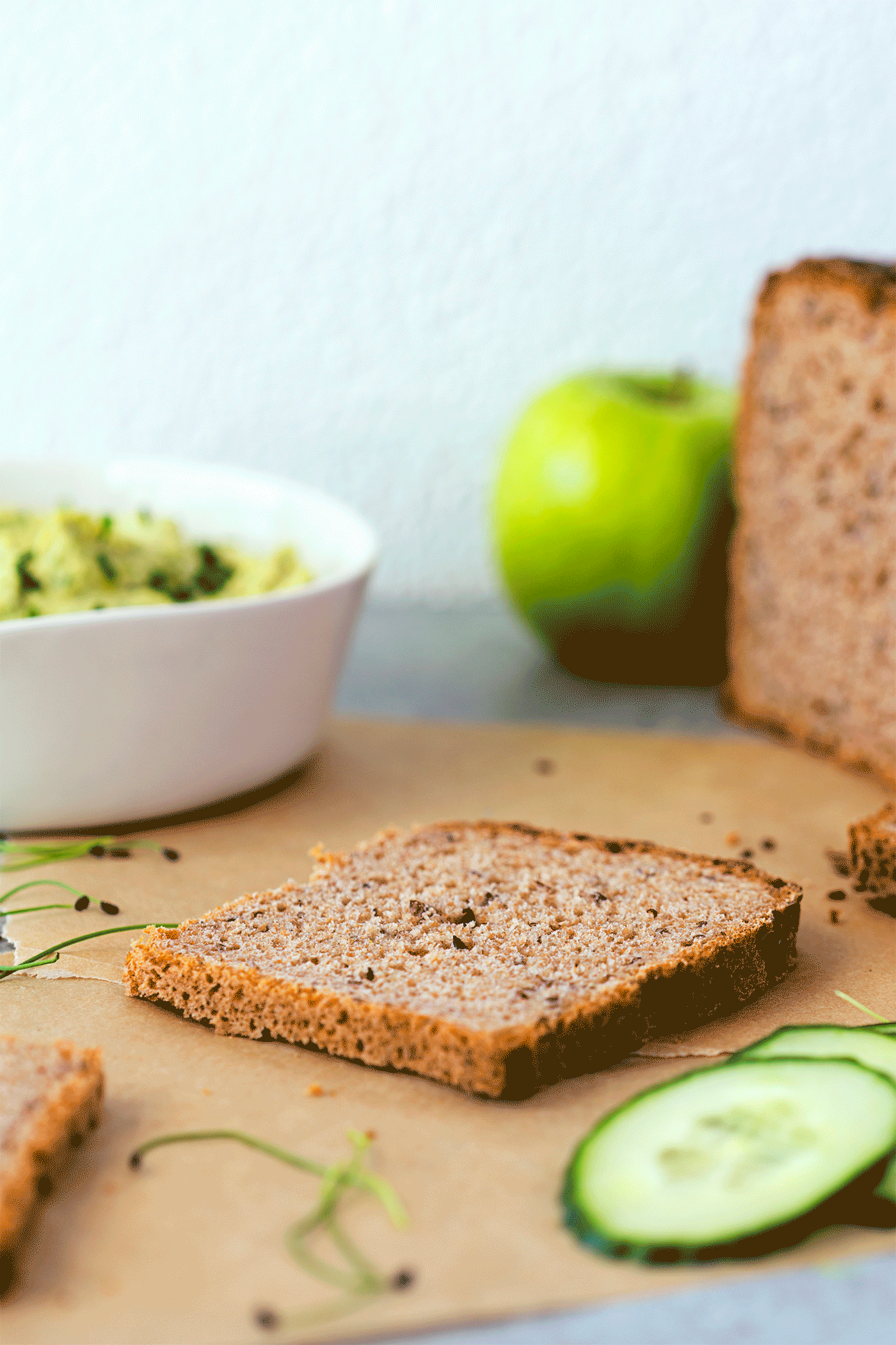 Animated gif of vegan sandwich layered with green hummus, crispy tofu, lettuce, avocado, green apple and fresh cucumber.