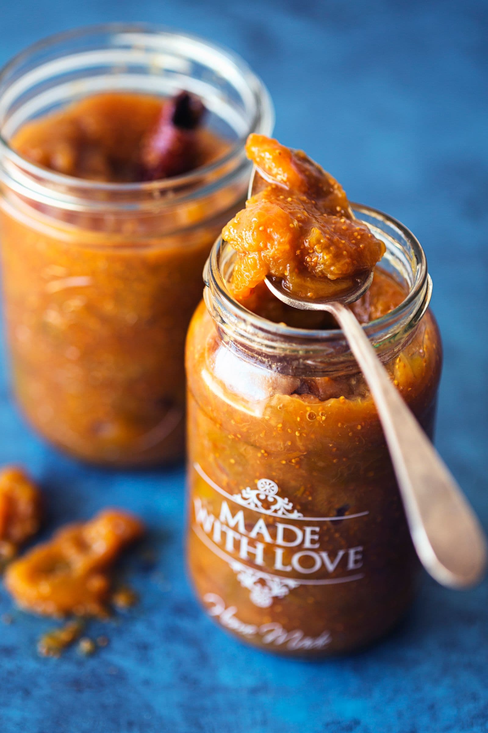 Spoonful of fig and ginger jam resting atop a jam jar labeled "Made With Love".