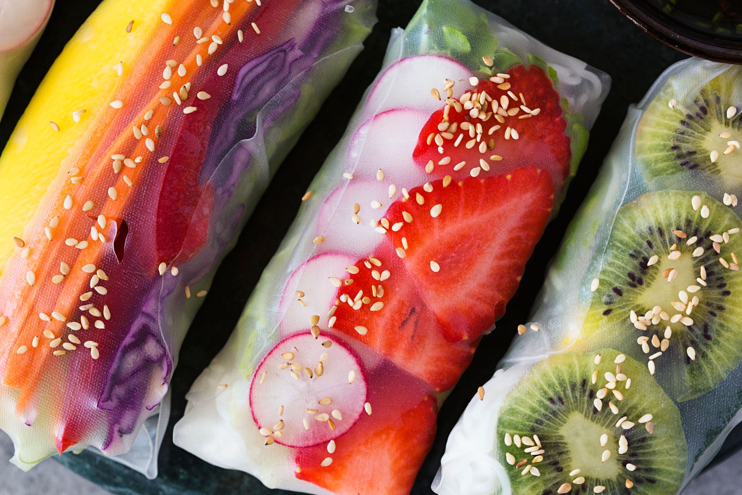 Detailed view of spring rolls showing mango, radish, strawberry and kiwi.