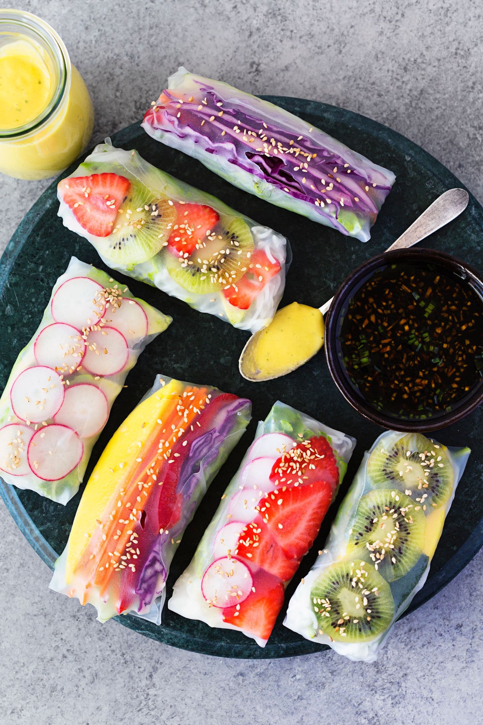 Finished rainbow spring rolls served with two dipping sauces.