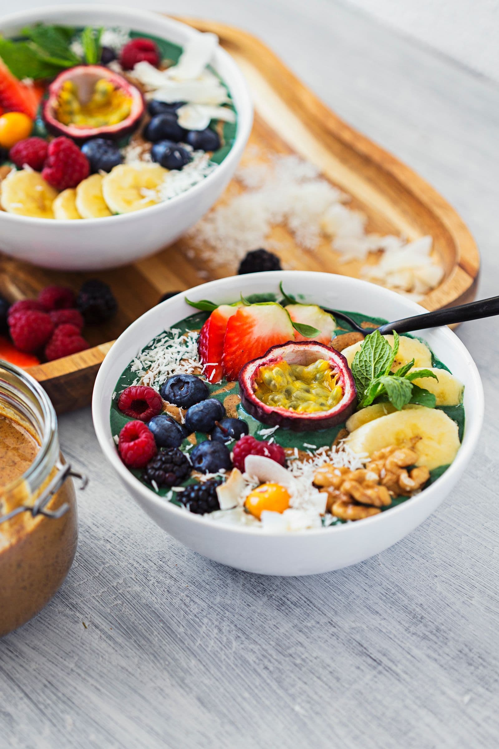 Taça de nicecream de spirulina com banana, maracujá, coco e frutos vermelhos.