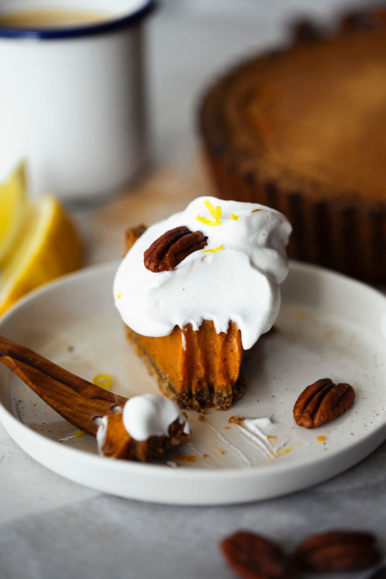 Garfo de madeira com pedaço de tarte de batata-doce com chantilly e raspas de limão.