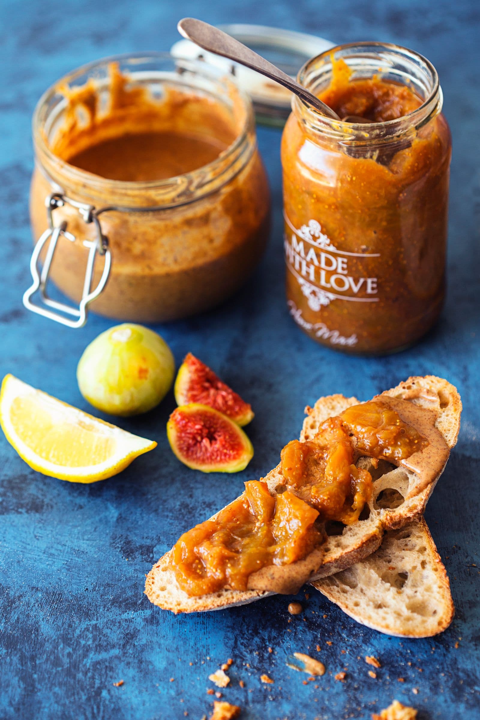 Rustic toast with fig and ginger jam, served next to lemon wedge and fig.