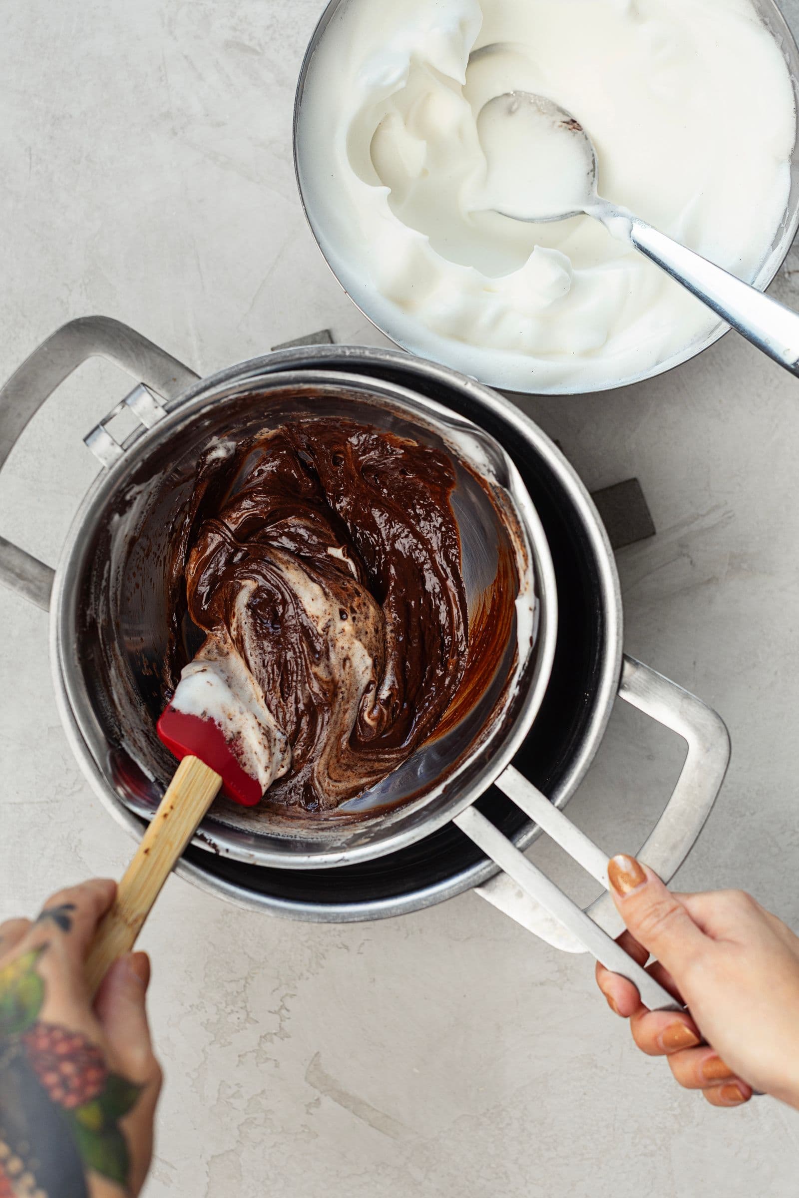 Aquafaba batida a ser cuidadosamente envolvida no chocolate derretido para criar uma mousse leve.