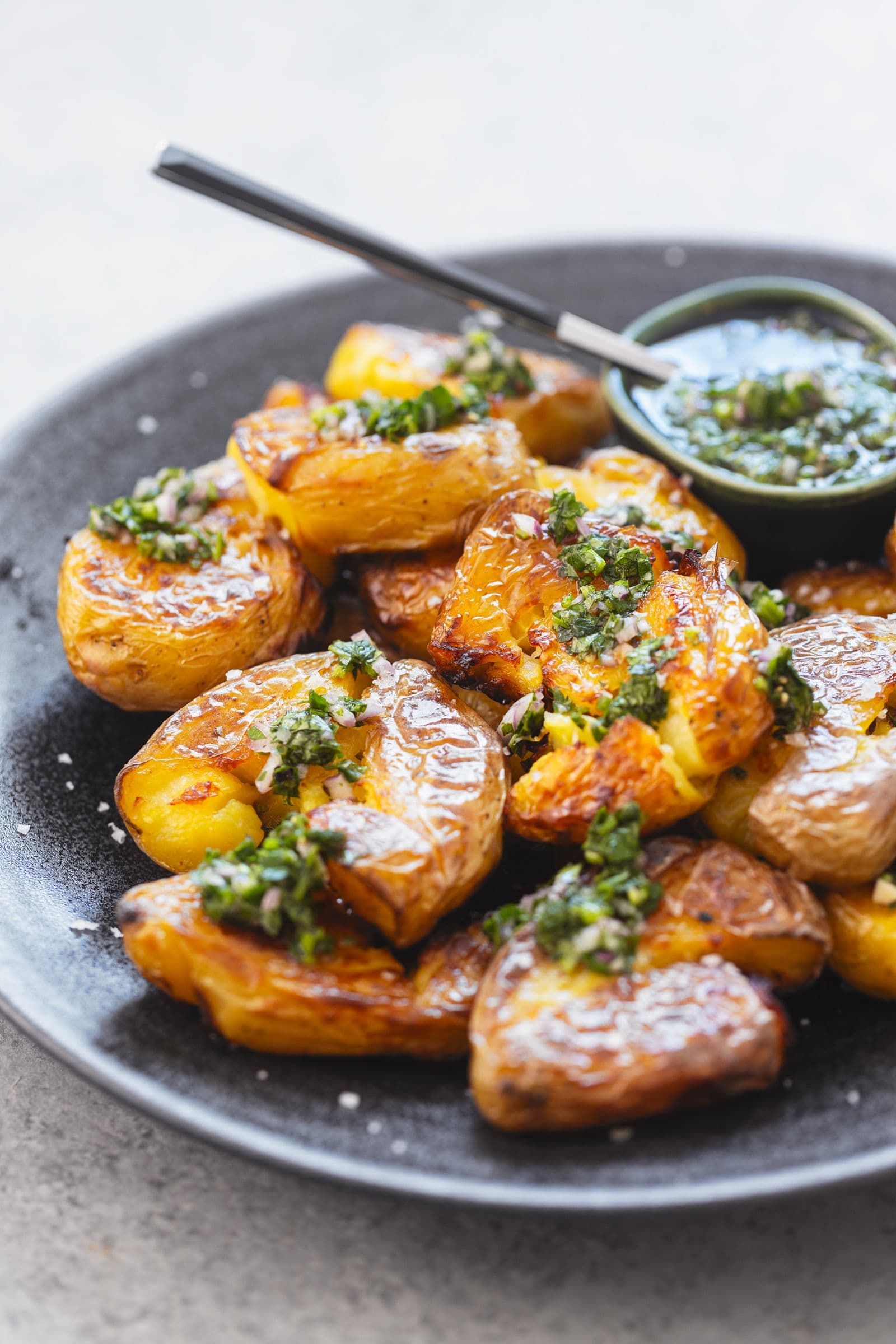 Batatas esmagadas e crocantes com molho de ervas frescas, prontas a saborear