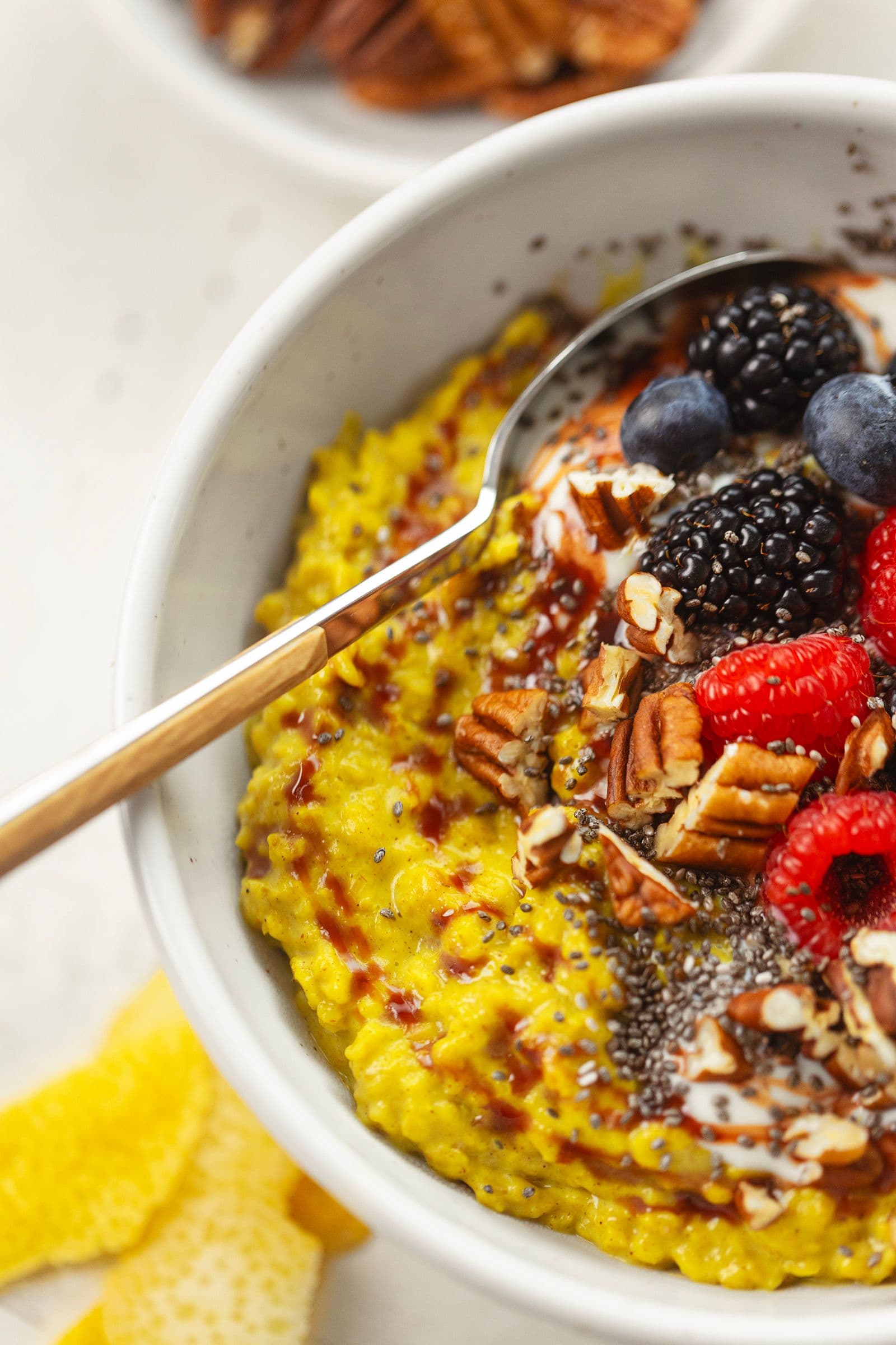 Pequeno-almoço colorido com papas vegan douradas, frutos silvestres e sementes, sobre fundo claro