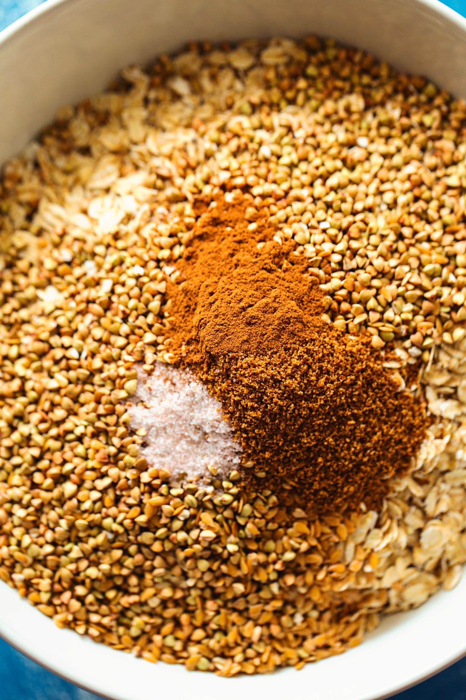 Close-up of spices, seeds and salt sprinkled over oats and cornflakes.