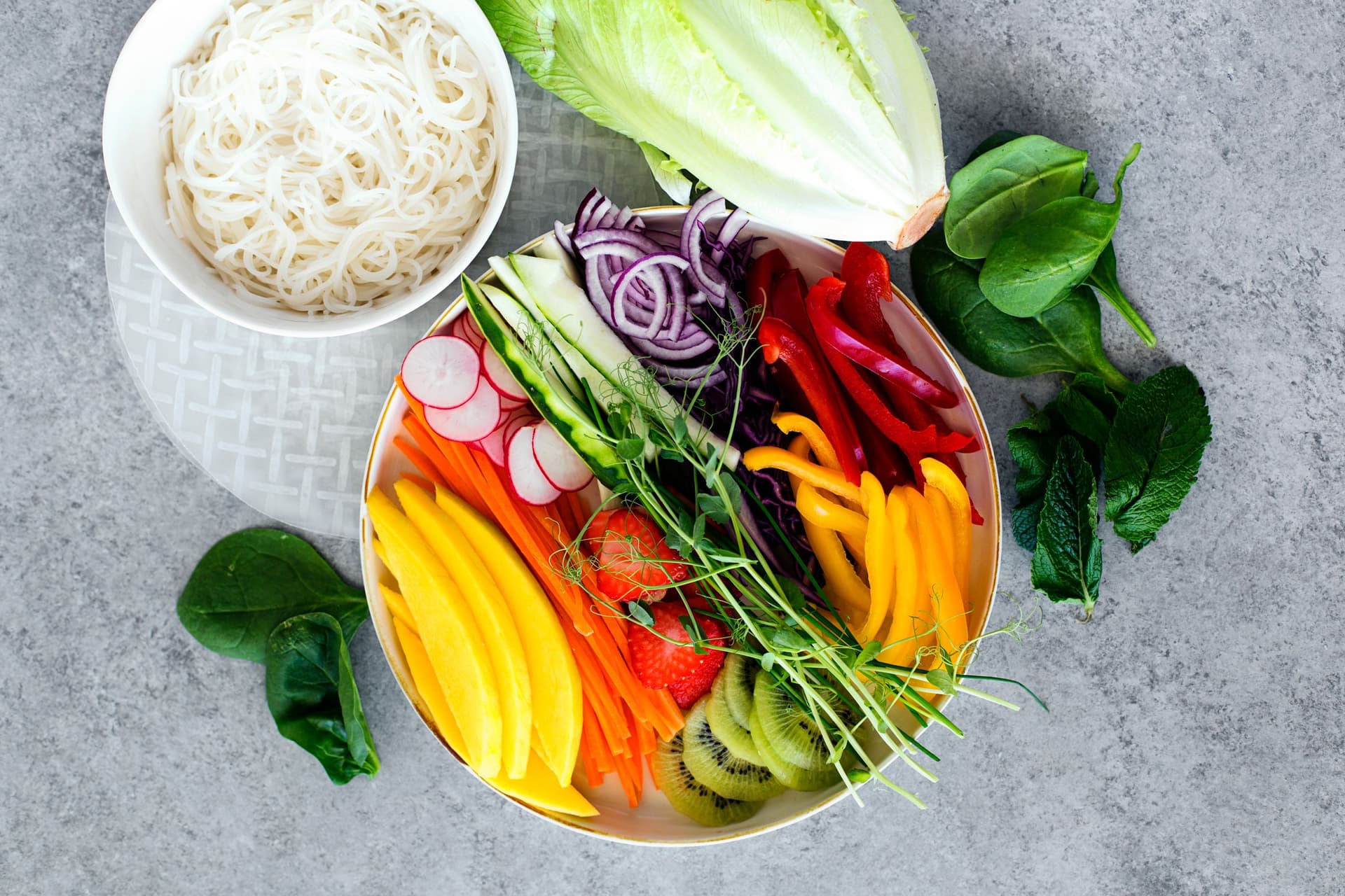 Rice noodles and chopped vegetables ready for assembly.