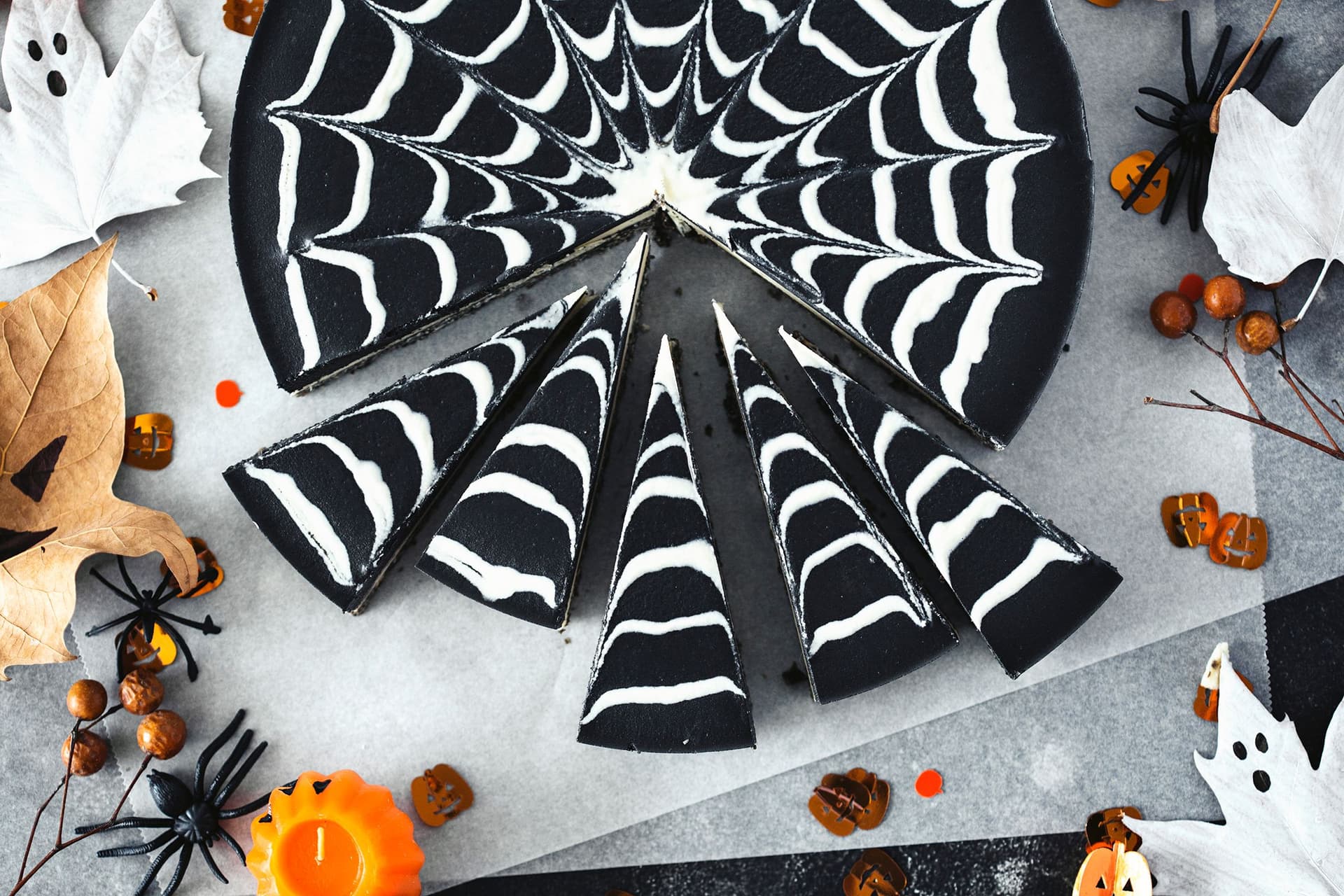 The Halloween cheesecake cut into even slices, spiderweb pattern still visible.