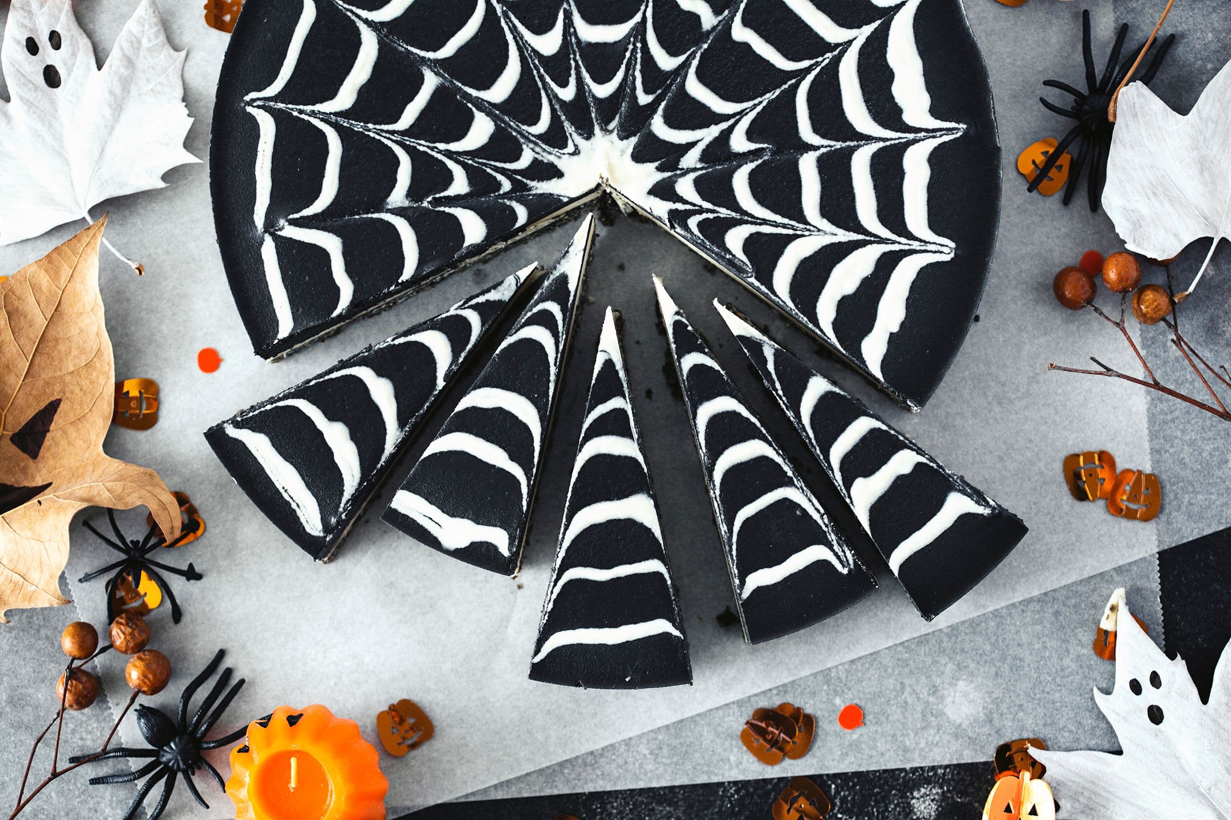 The Halloween cheesecake cut into even slices, spiderweb pattern still visible.