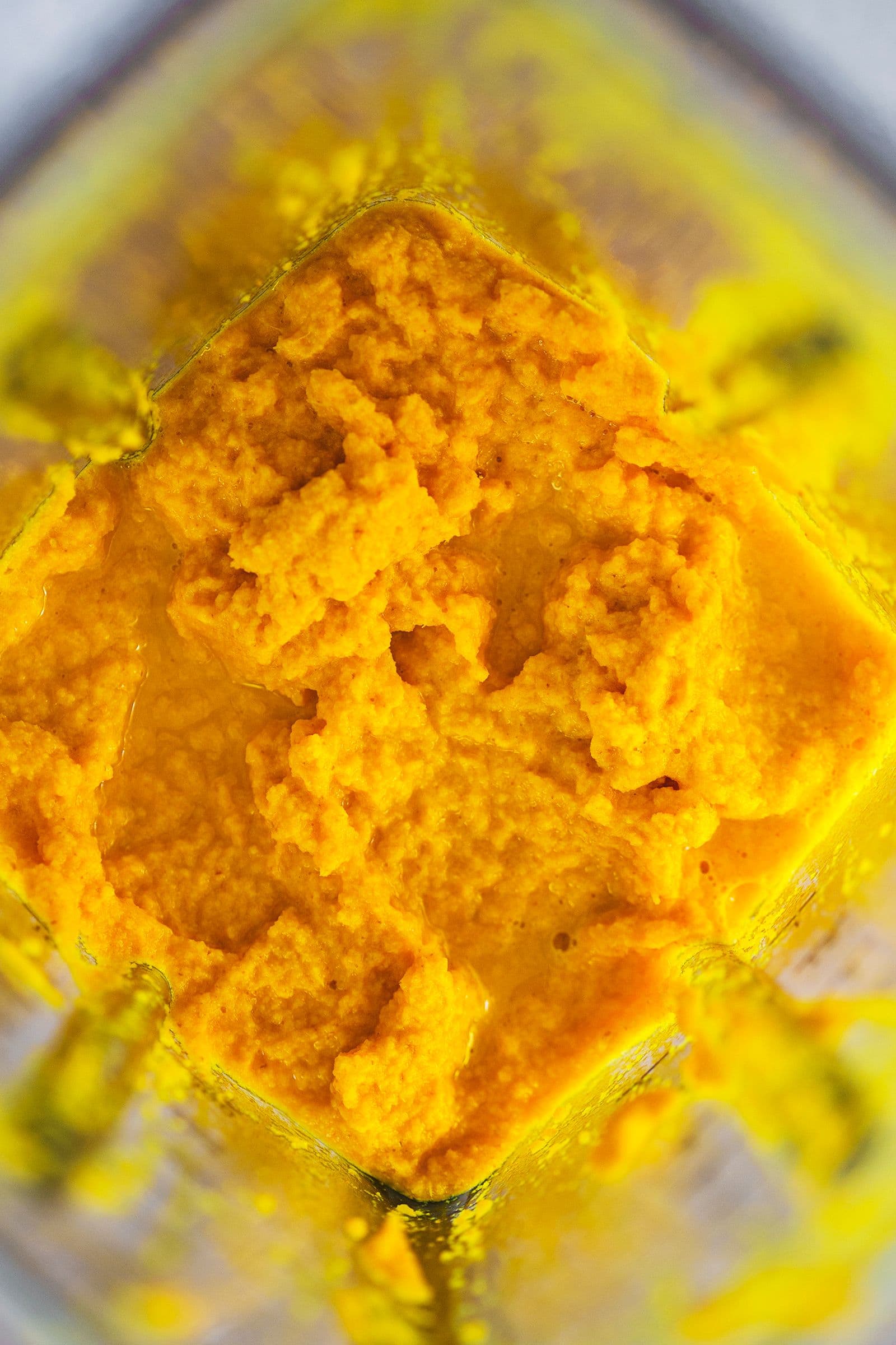 Mistura de gengibre e curcuma acabada de triturar, de cor laranja intensa.