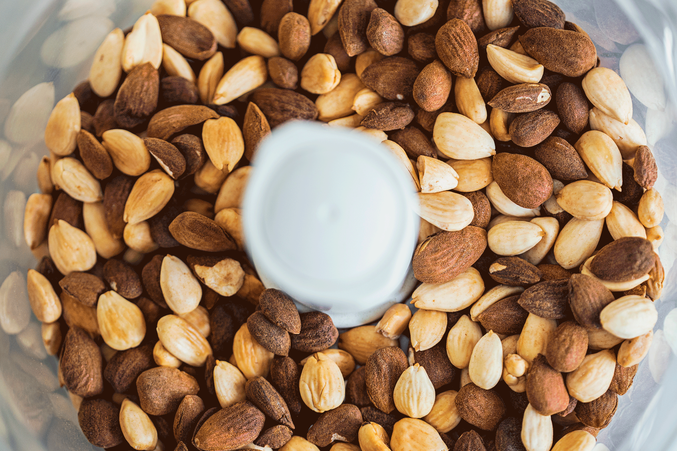 Animated gif of almonds breaking down into creamy butter inside a food processor.