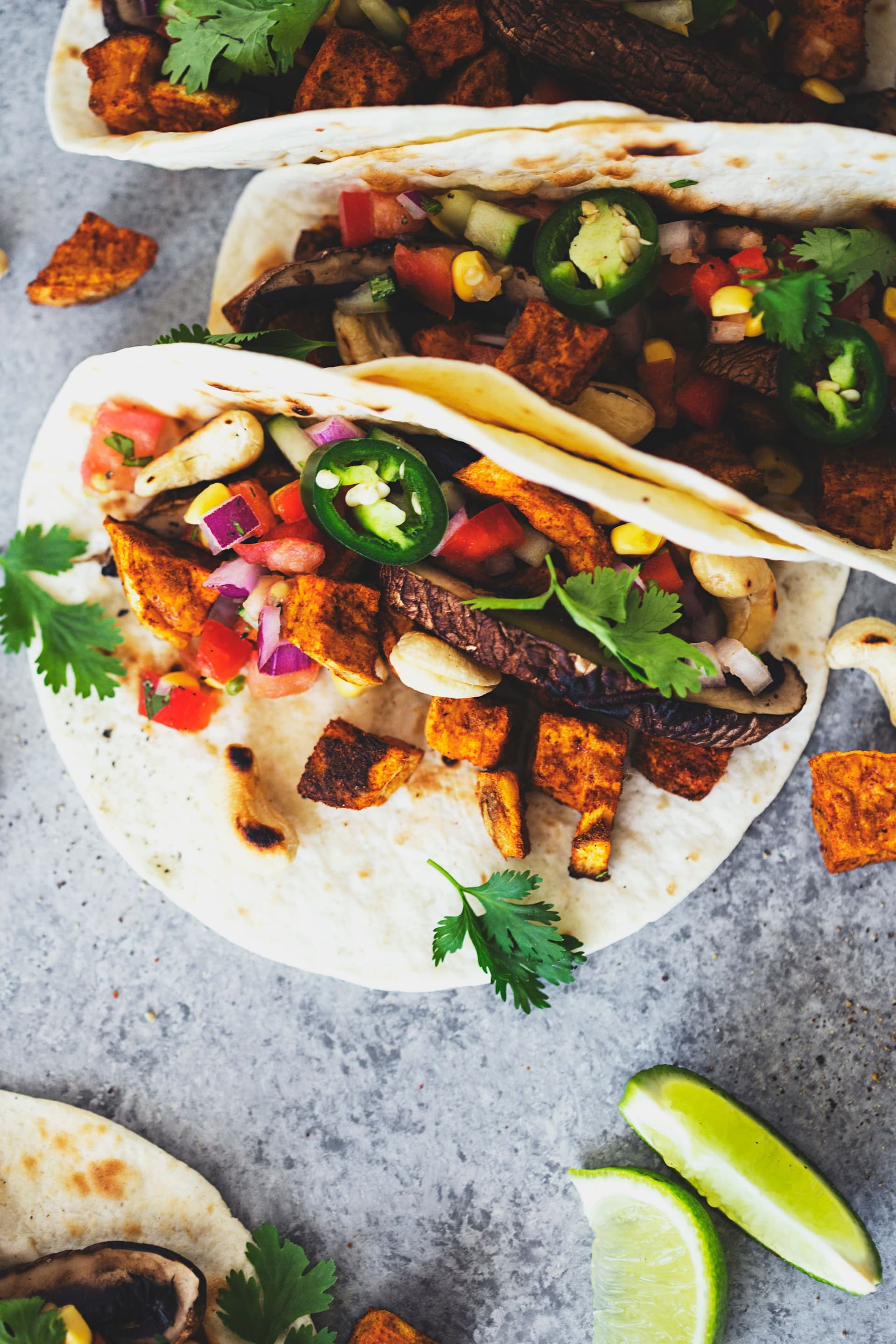 Close-up of a taco with sweet potato, mushrooms, salsa and herbs.