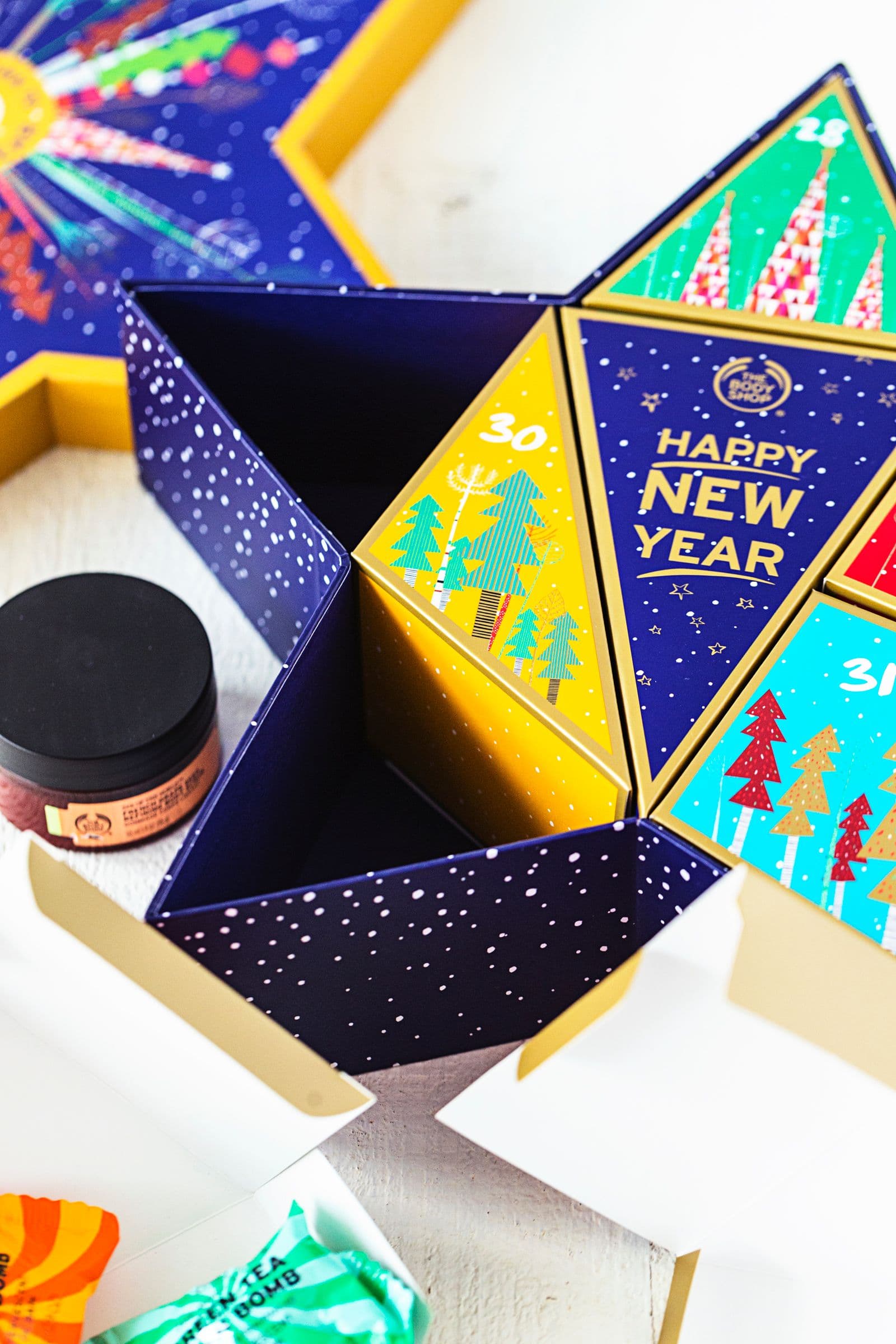Embalagem festiva da The Body Shop com caixas numeradas e produtos coloridos no interior.