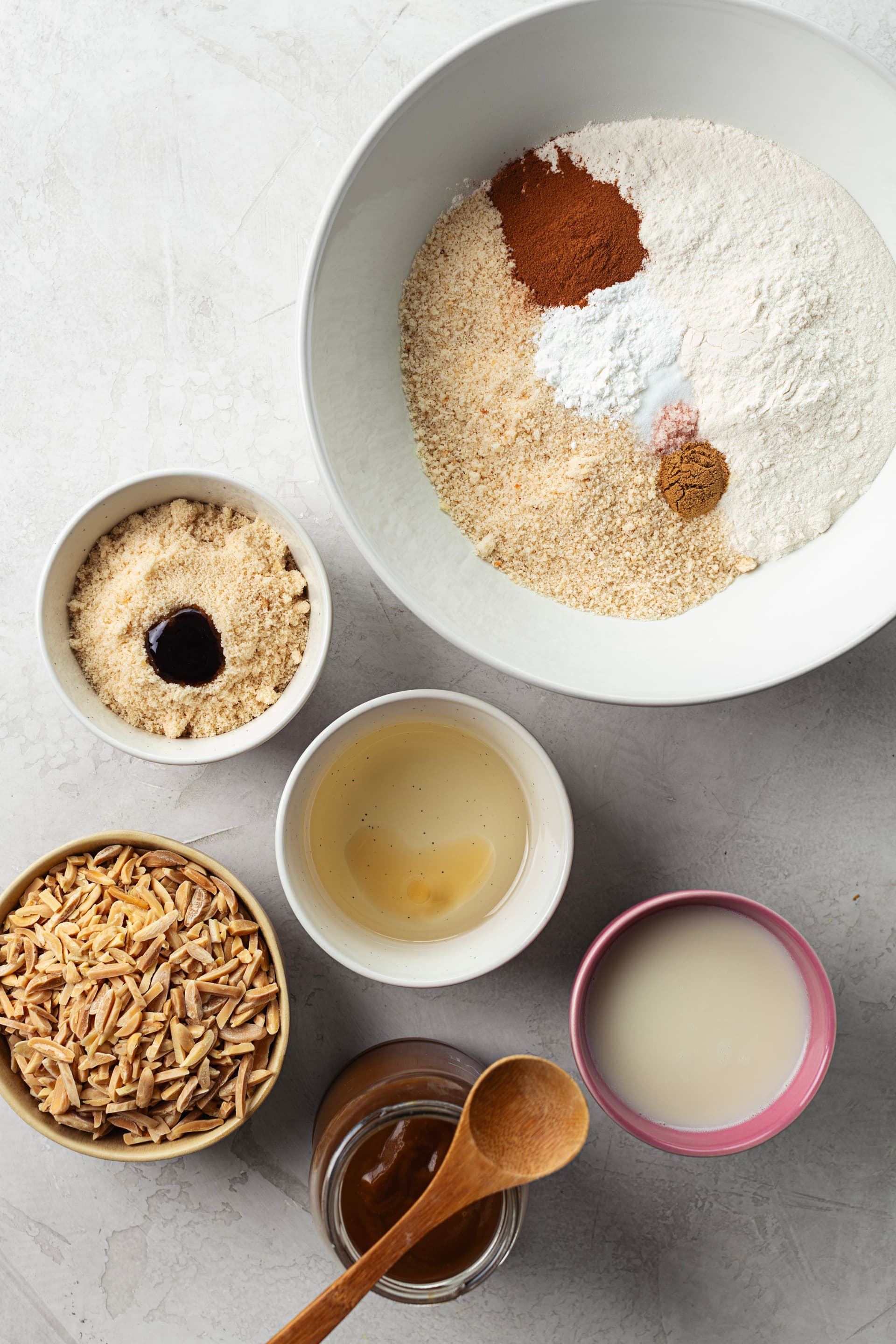 Ingredientes para bolo de amêndoa vegan: farinha, especiarias, açúcar mascavado, amêndoas palitadas, caramelo de coco e bebida vegetal.