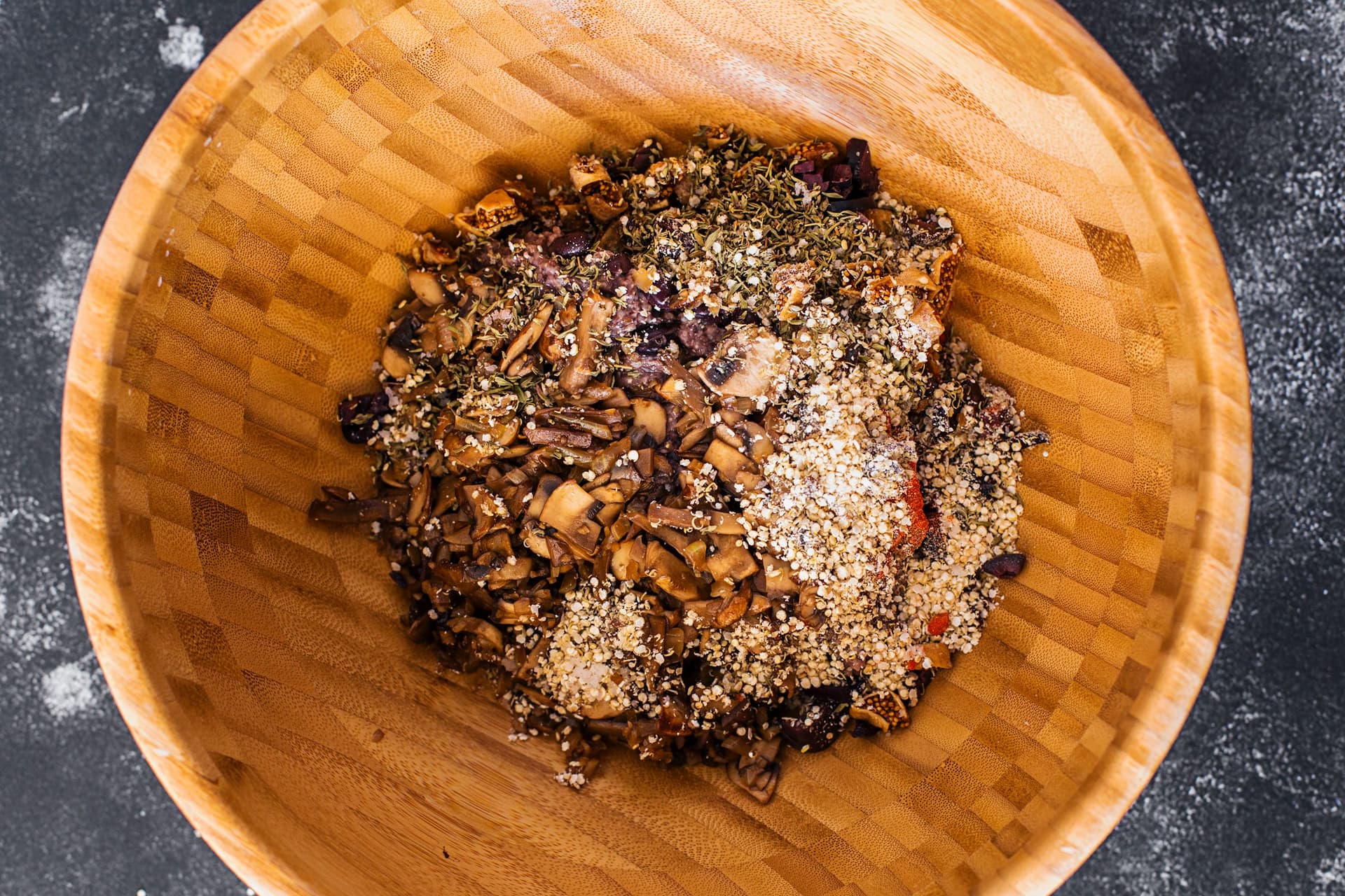 Overhead of a wooden bowl with mixed black bean burger ingredients.
