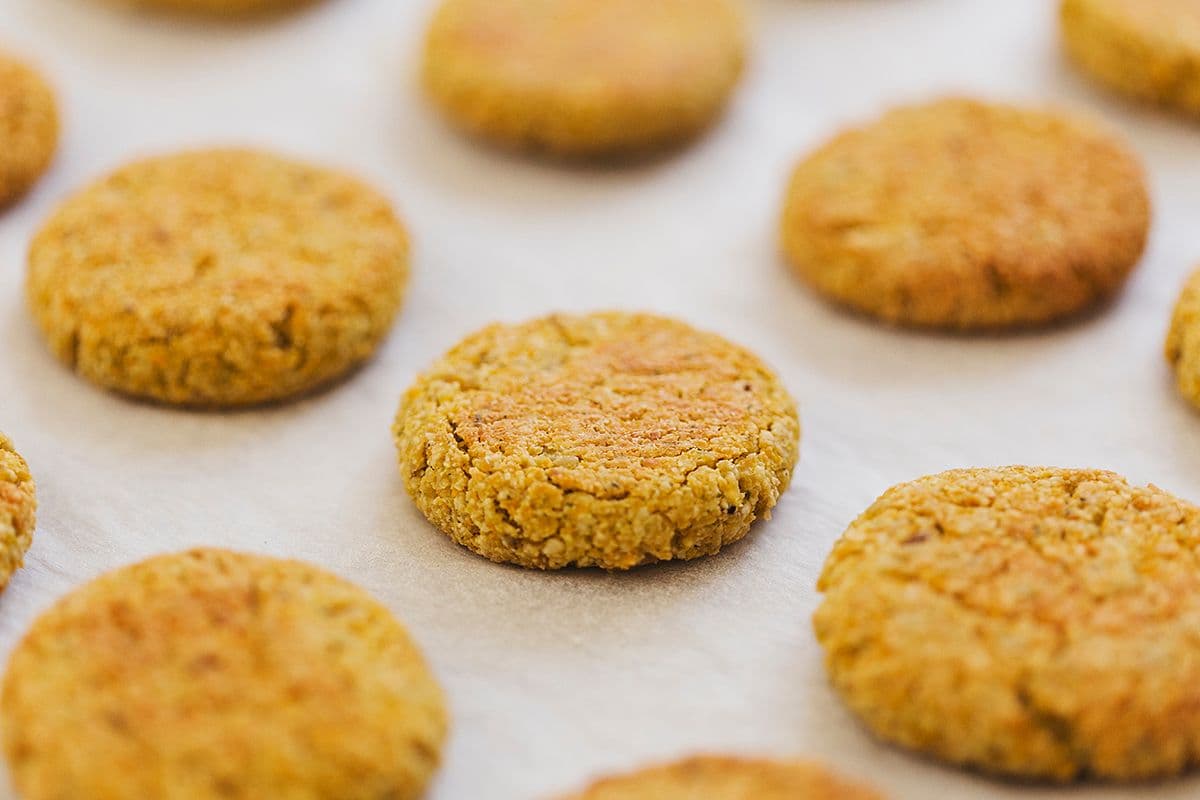 Several baked falafels arranged on a baking tray.