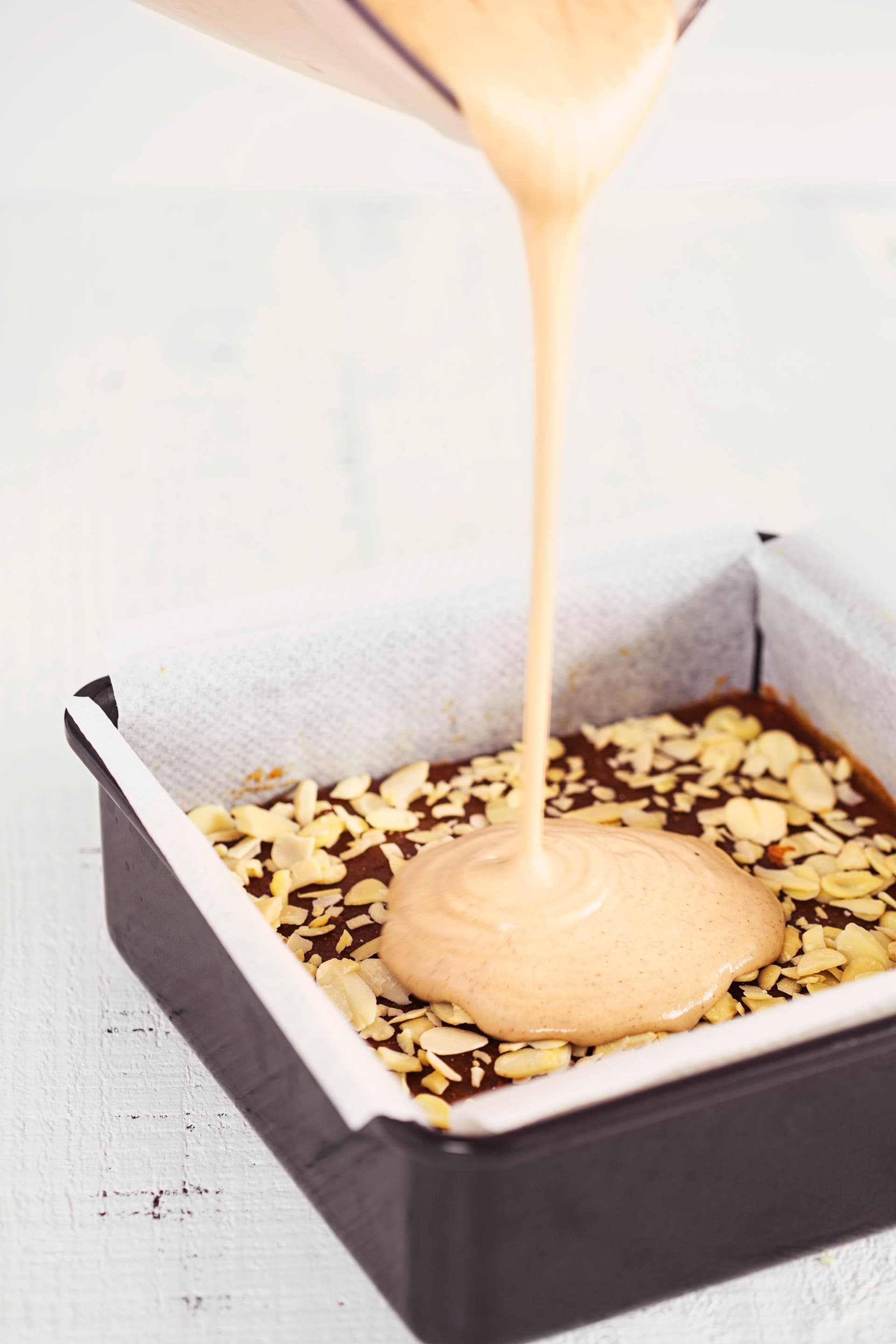 A verter creme de amêndoa e caju sobre a base de caramelo.