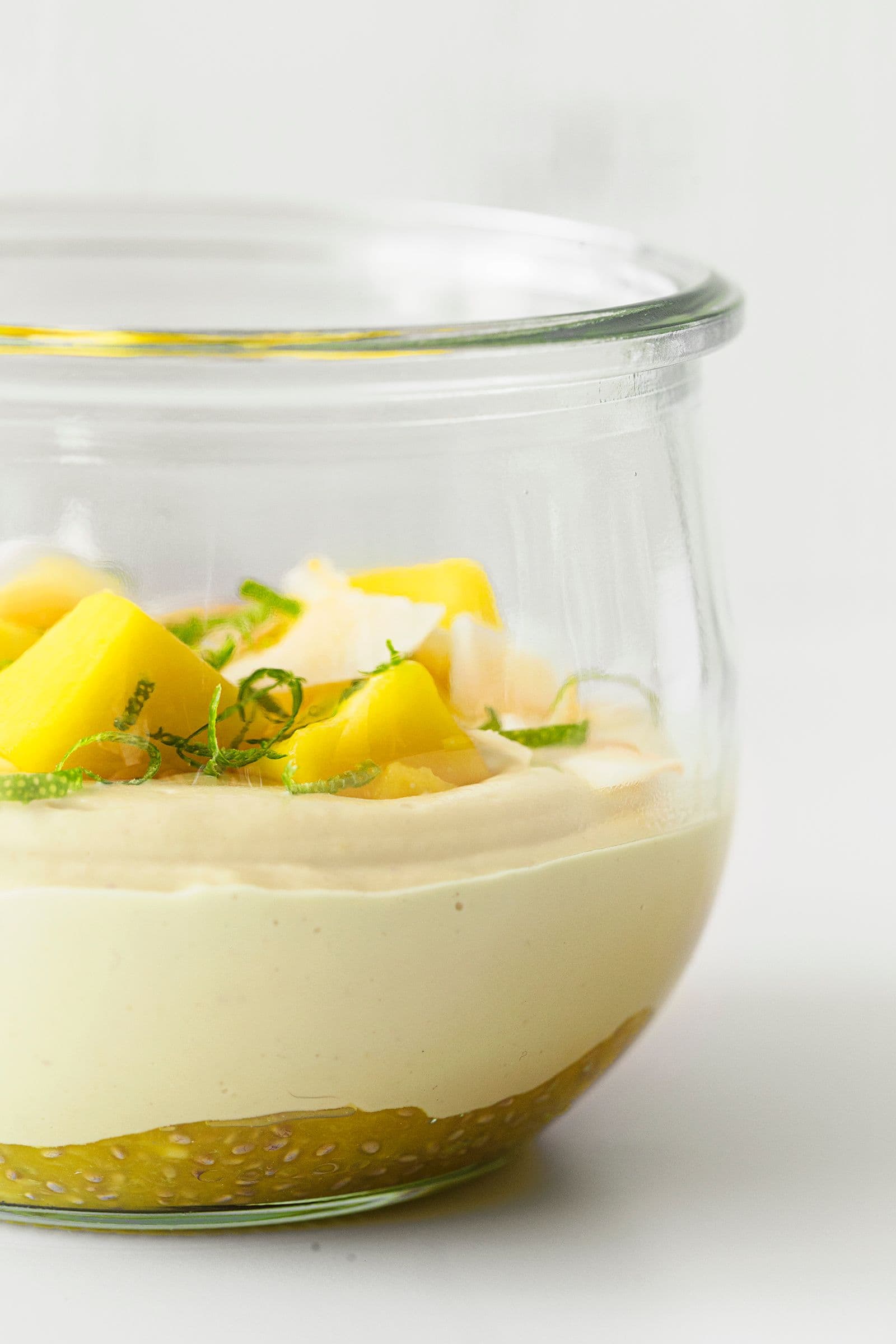 Close-up side view of mango cashew yogurt with visible mango chia jam base and mango topping.