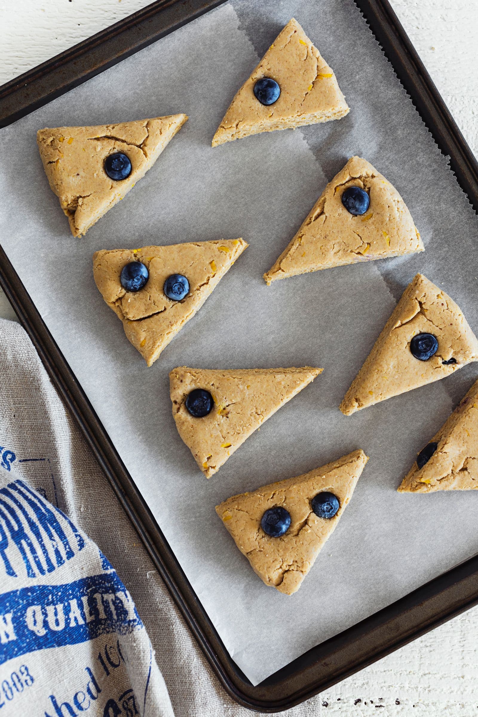 Massa dos scones de limão cortada em triângulos, pronta para ir ao forno.