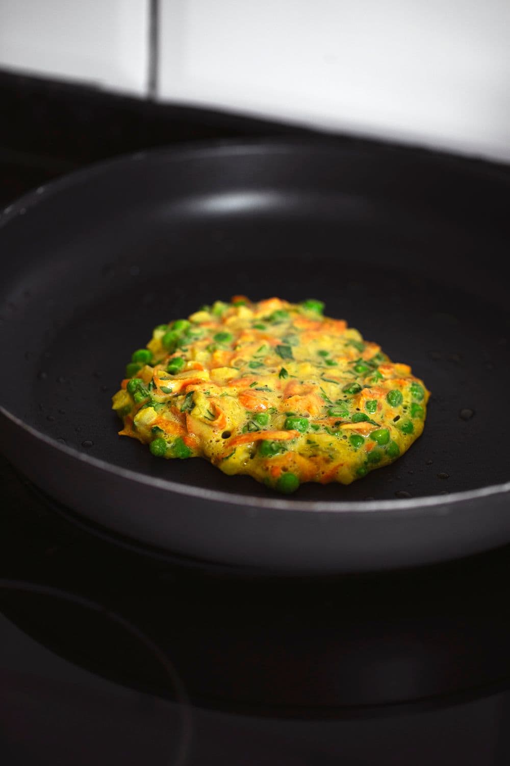 Patanisca de legumes e grão-de-bico a cozinhar numa frigideira antiaderente