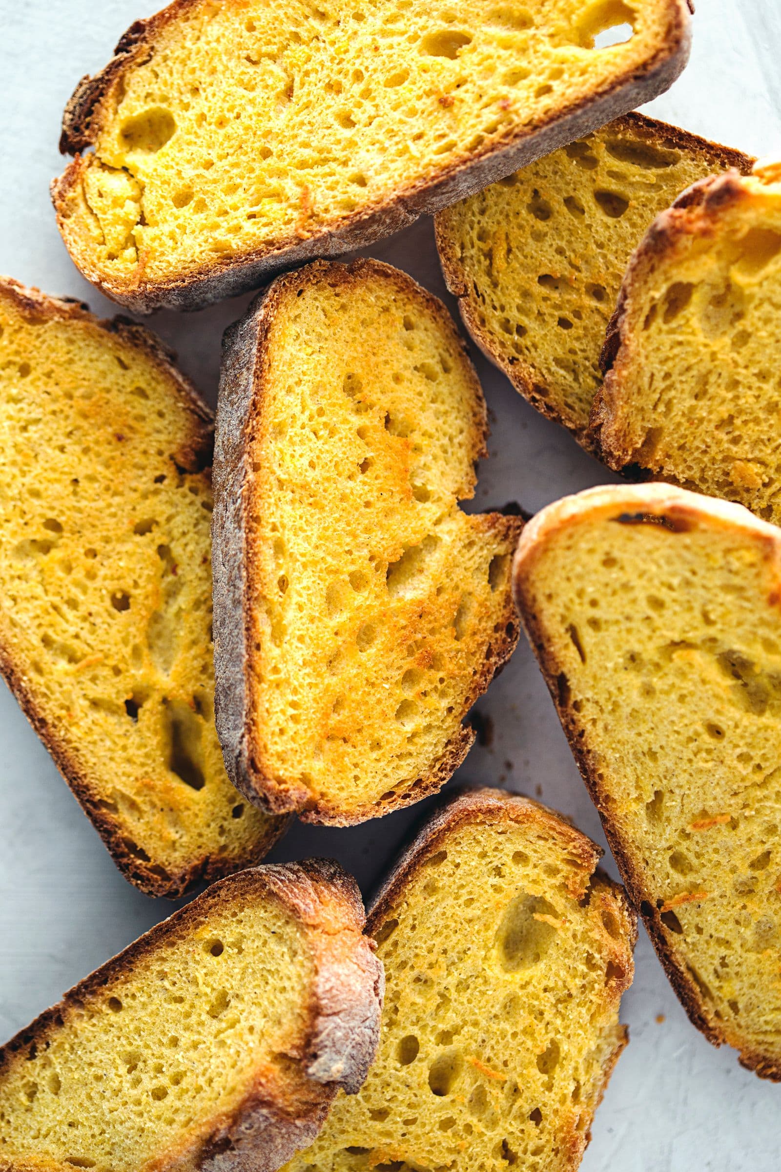Thick slices of cornbread laid out, ready to be crumbled.
