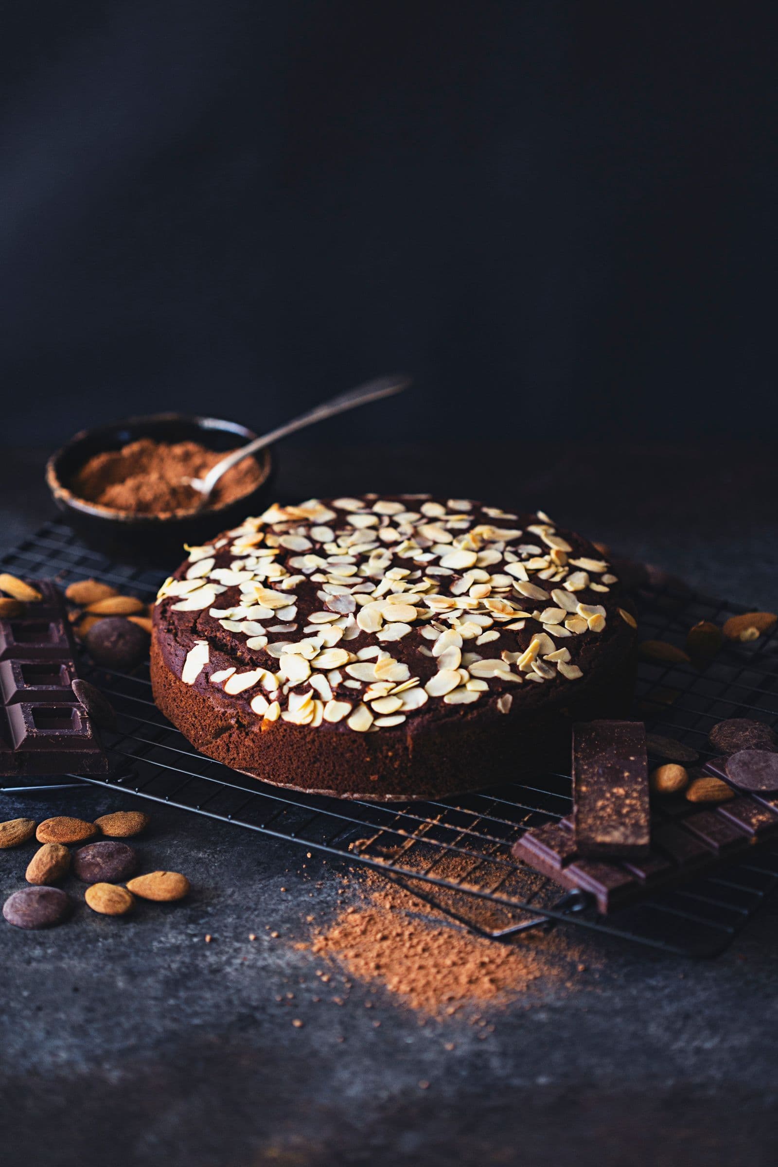 Bolo acompanhado de cacau, chocolate e amêndoas inteiras.