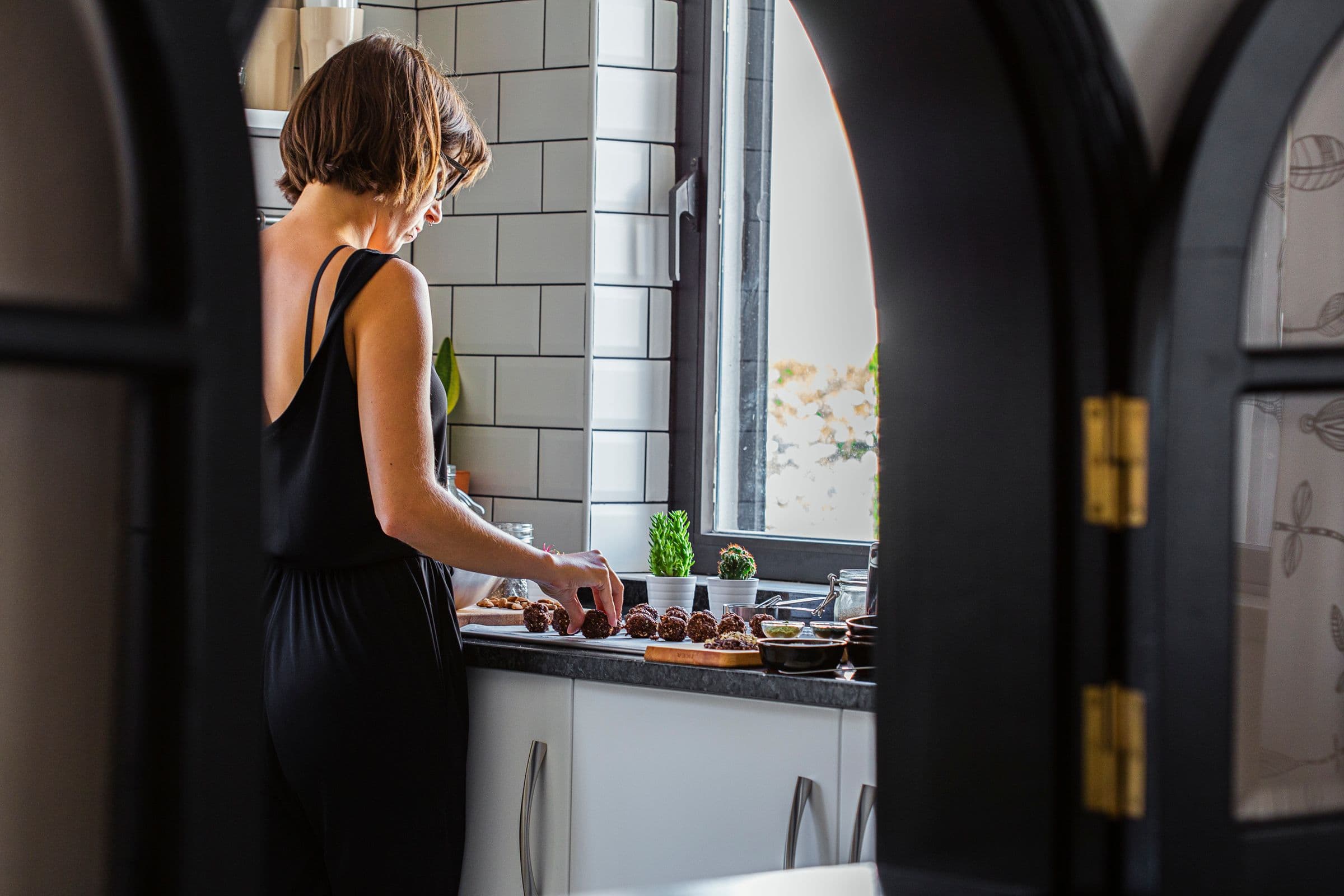 Rita shaping energy balls in a bright kitchen.