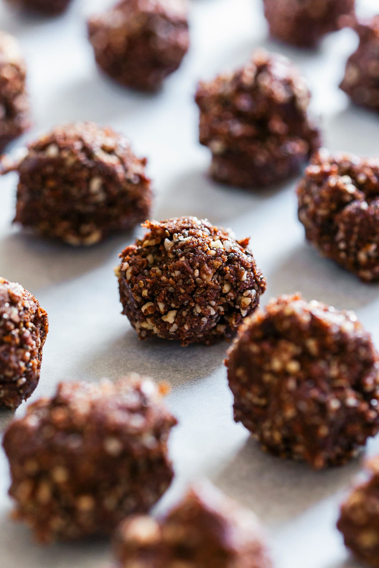 Rows of cacao energy balls resting on parchment paper.