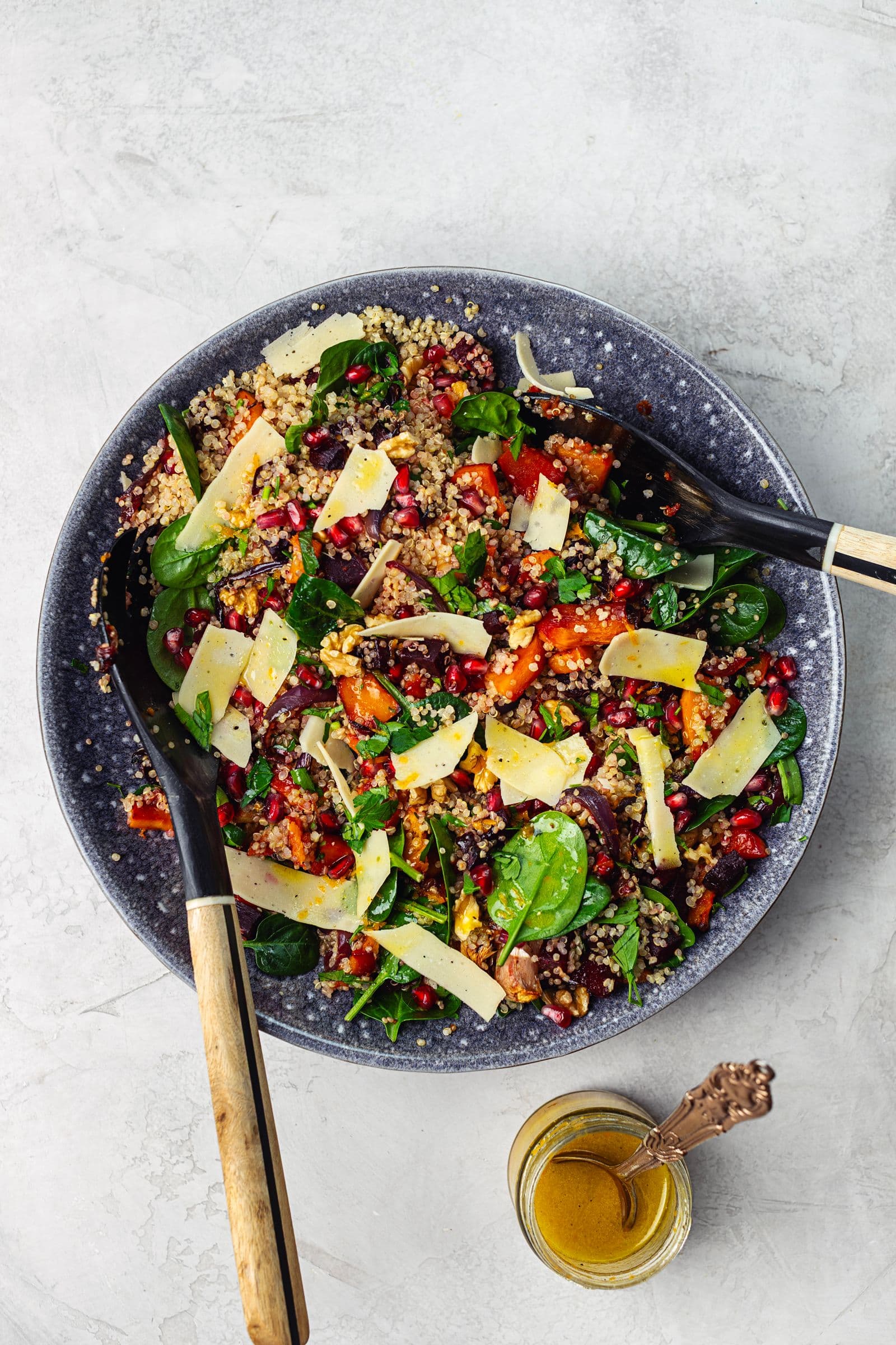 Salada de inverno servida numa taça com vinagrete de laranja ao lado.