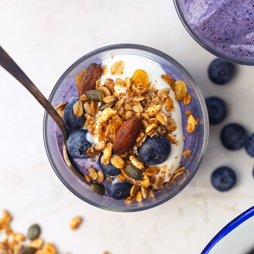 Mousse vegan de mirtilos com granola crocante, mirtilos frescos e iogurte.