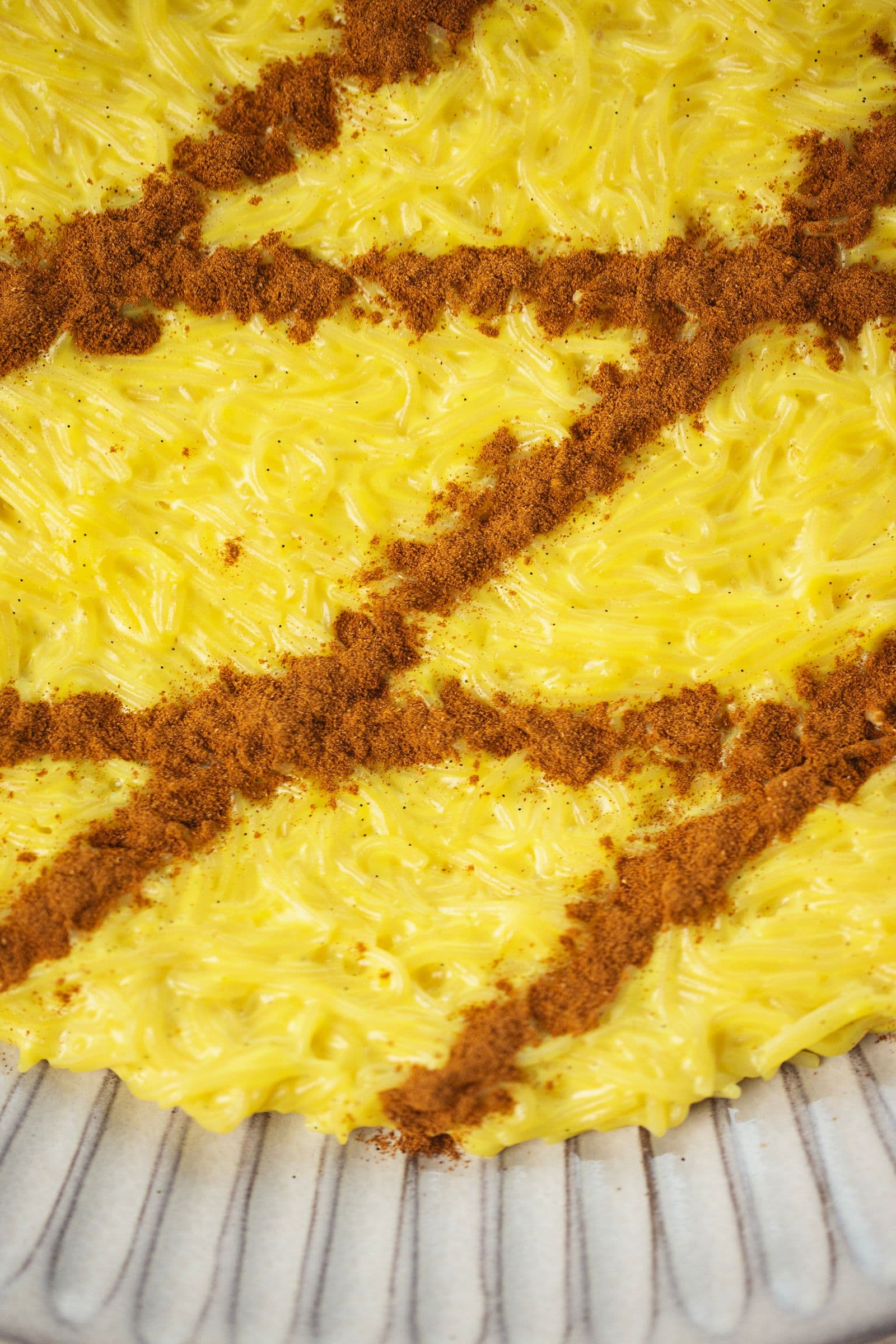 Macro shot of vegan Aletria, highlighting the glossy noodles and diagonal cinnamon stripes.