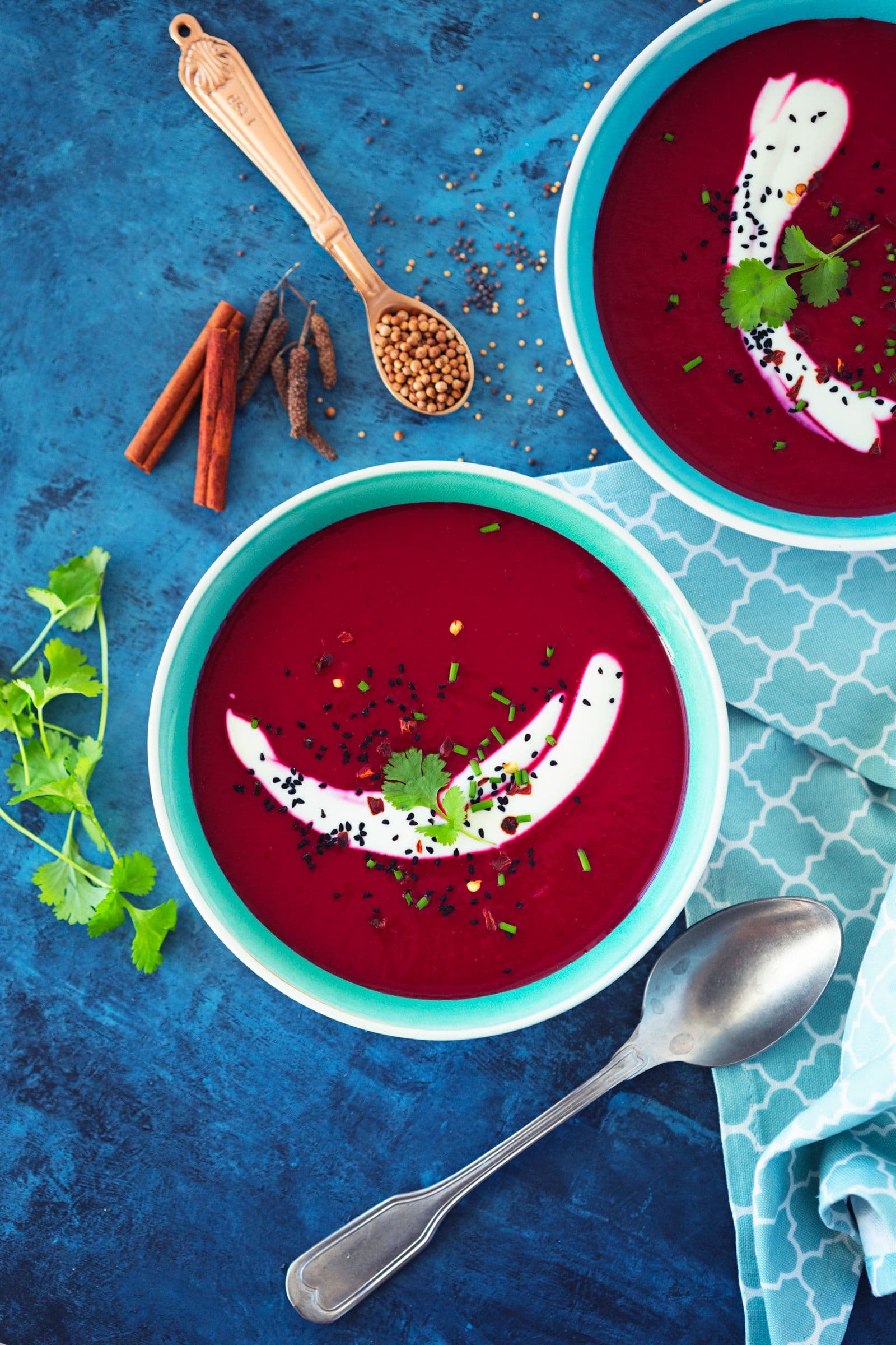 Beetroot and apple soup served with coconut yogurt, fresh herbs, and a sprinkle of nigella seeds.