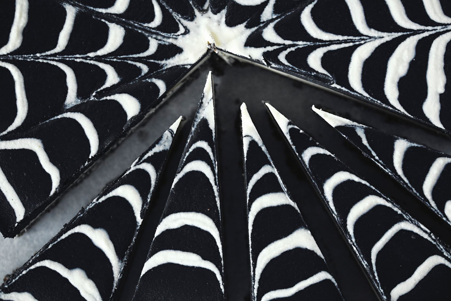 Spiderweb cheesecake slices arranged in a circle, focusing on the pointed ends.