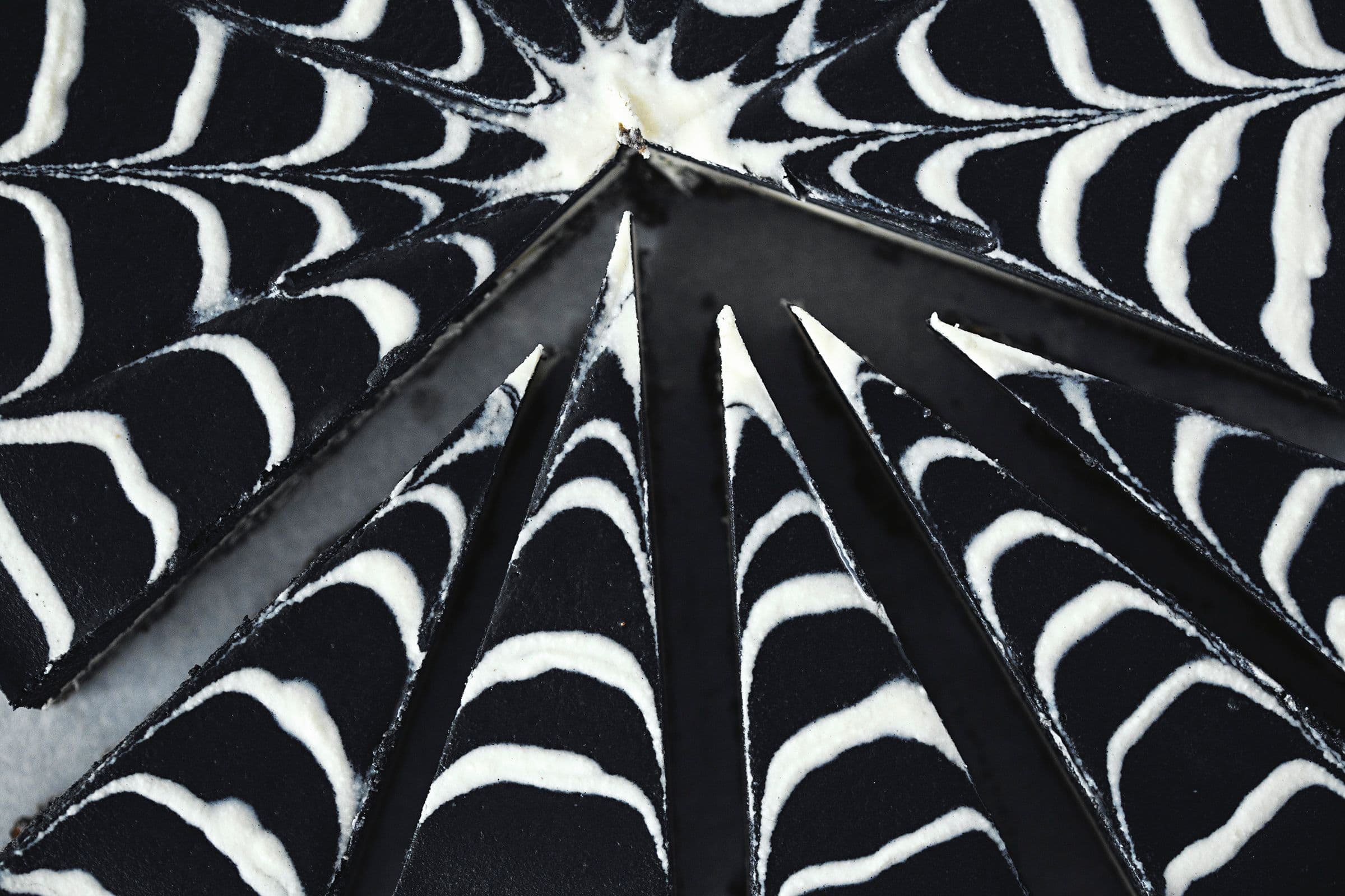 Spiderweb cheesecake slices arranged in a circle, focusing on the pointed ends.