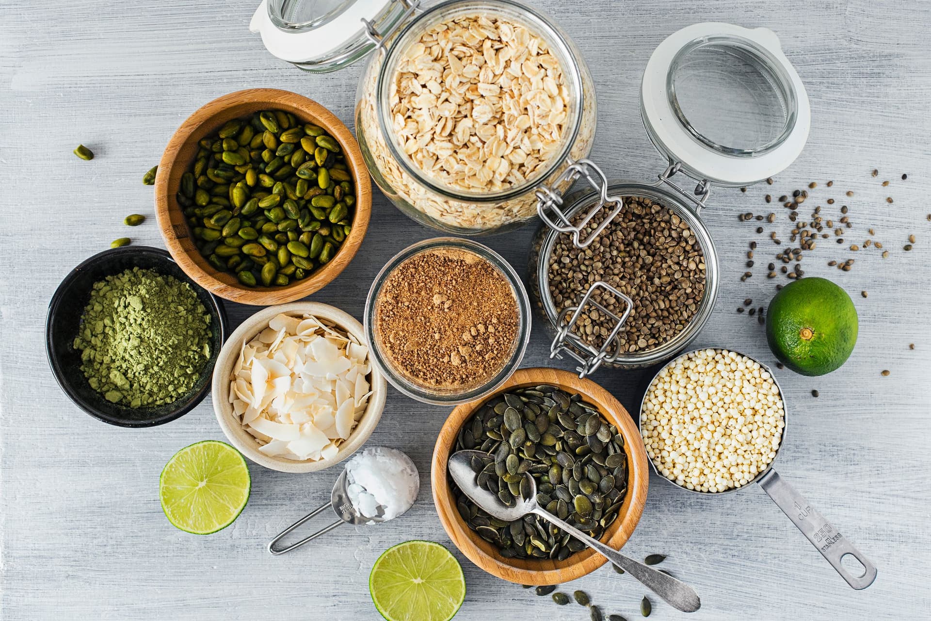 Ingredientes para a granola: flocos de aveia, sementes, lima, coco, pó de erva de trigo e adoçantes.