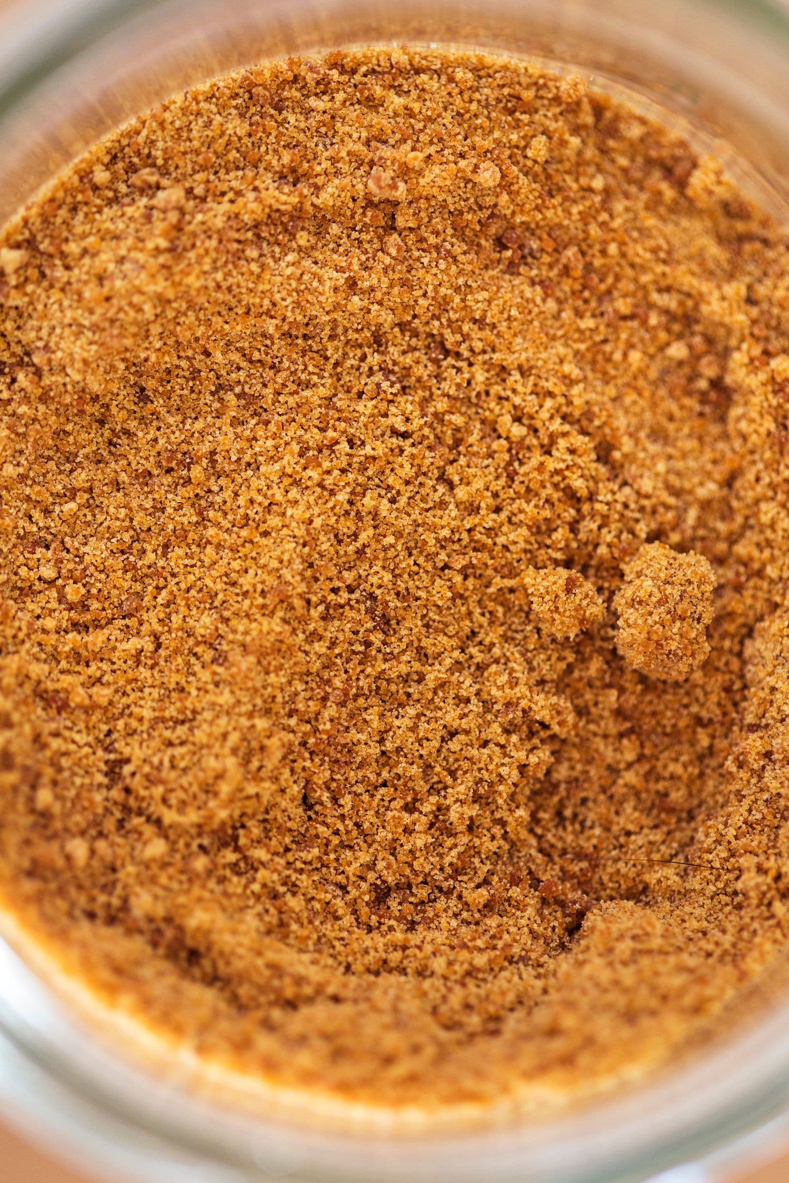 Close-up of coconut sugar in a jar, viewed from above.