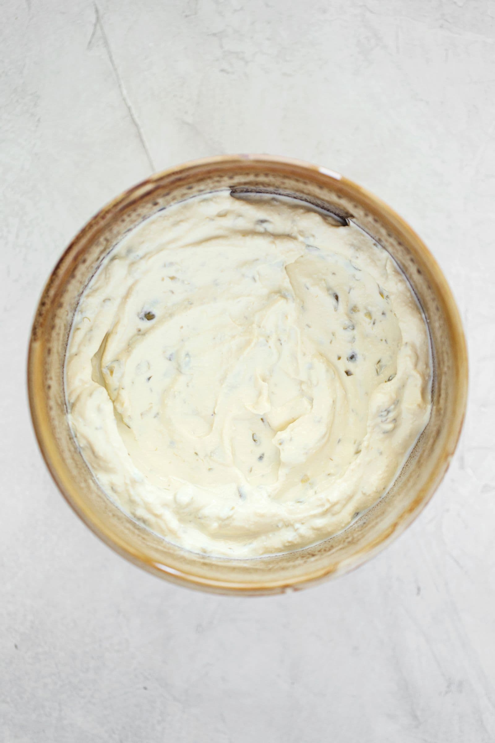 Small bowl filled with creamy vegan tofu spread for sushi rolls.