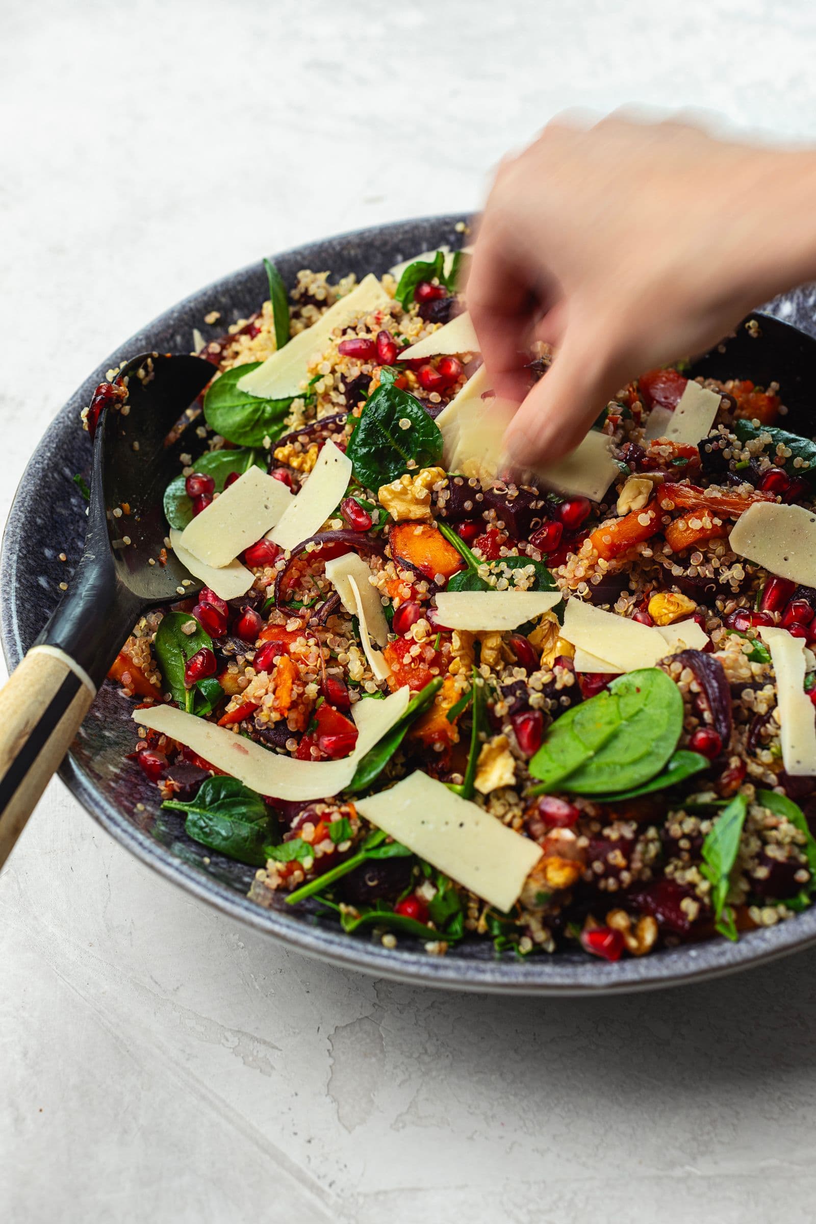 Adicionar lascas de queijo vegan a uma salada de quinoa com vegetais assados e romã.