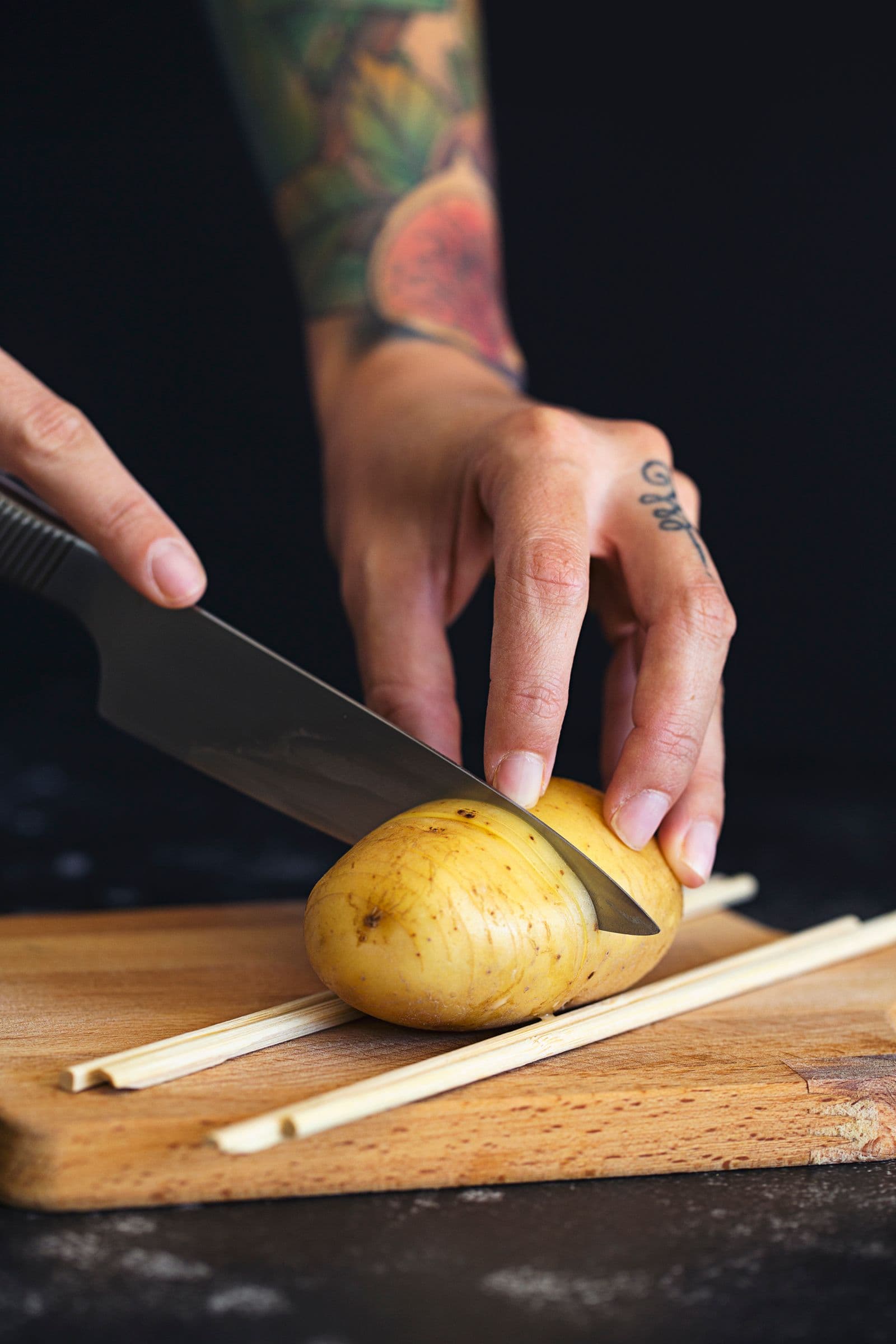 Precision slicing of a raw potato with chopsticks used as a stop guide.