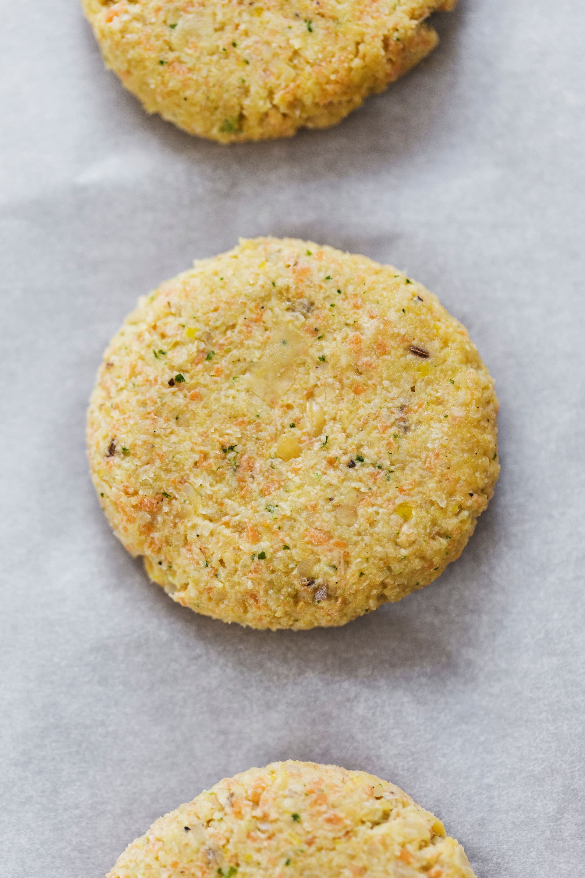 Unbaked falafel patty on parchment-lined tray.