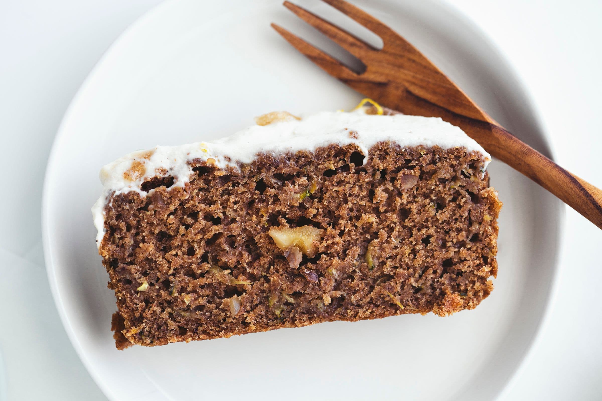 Inside view of zucchini cake showing moist texture and walnuts.