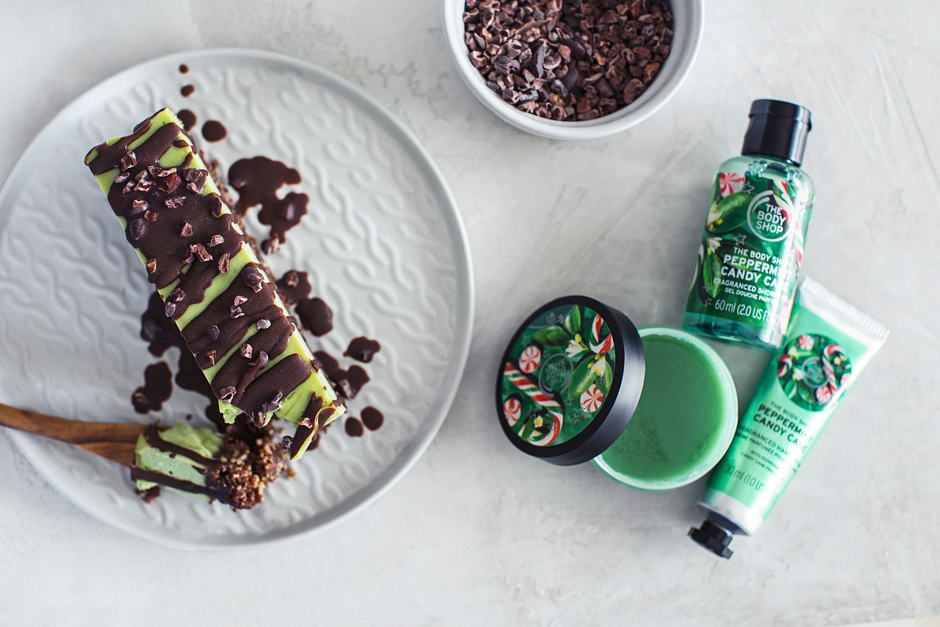 Flat lay of a vegan dessert and candy cane-scented skincare from The Body Shop.