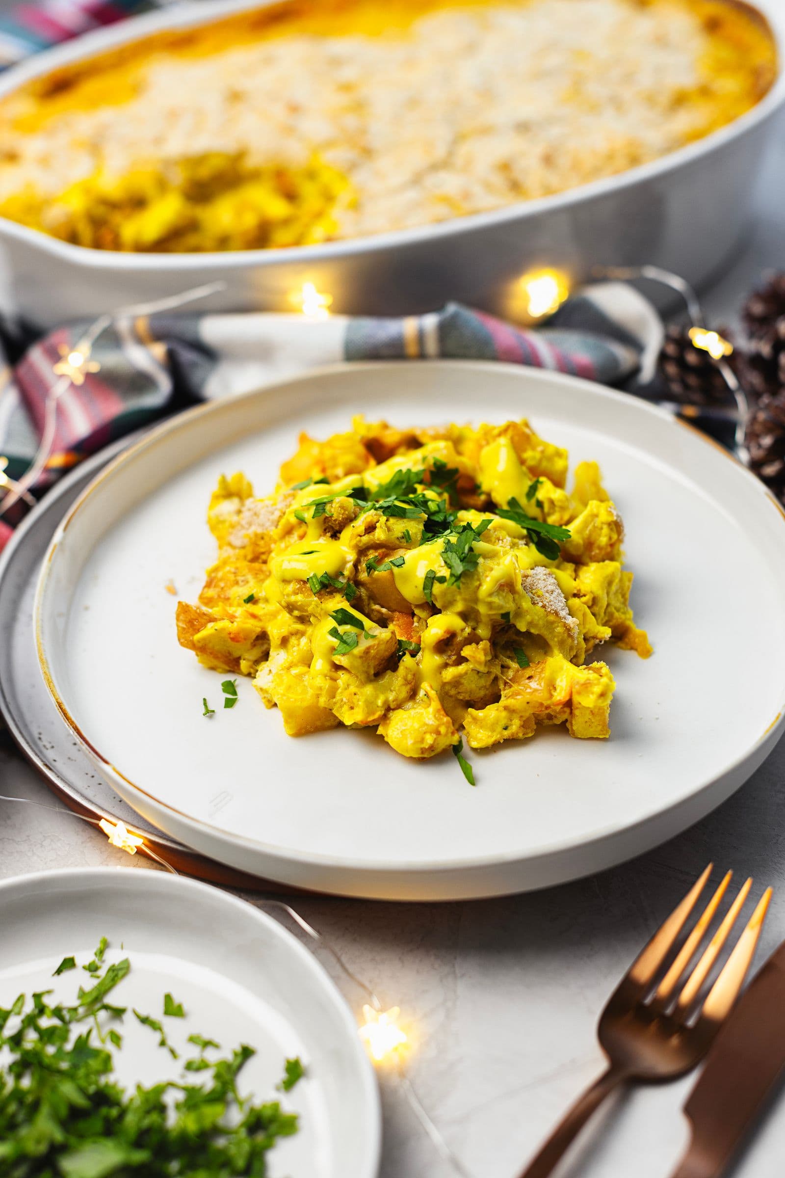 Plate with a serving of creamy gratin topped with chopped fresh parsley.