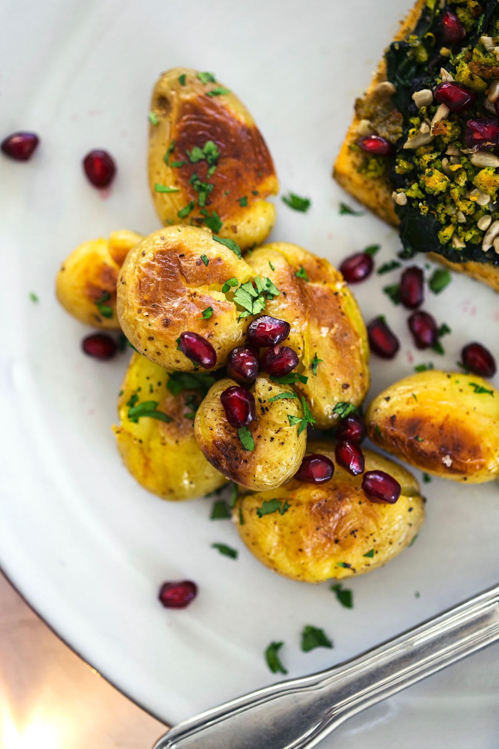 Porção de tofu assado e batatas num prato branco.