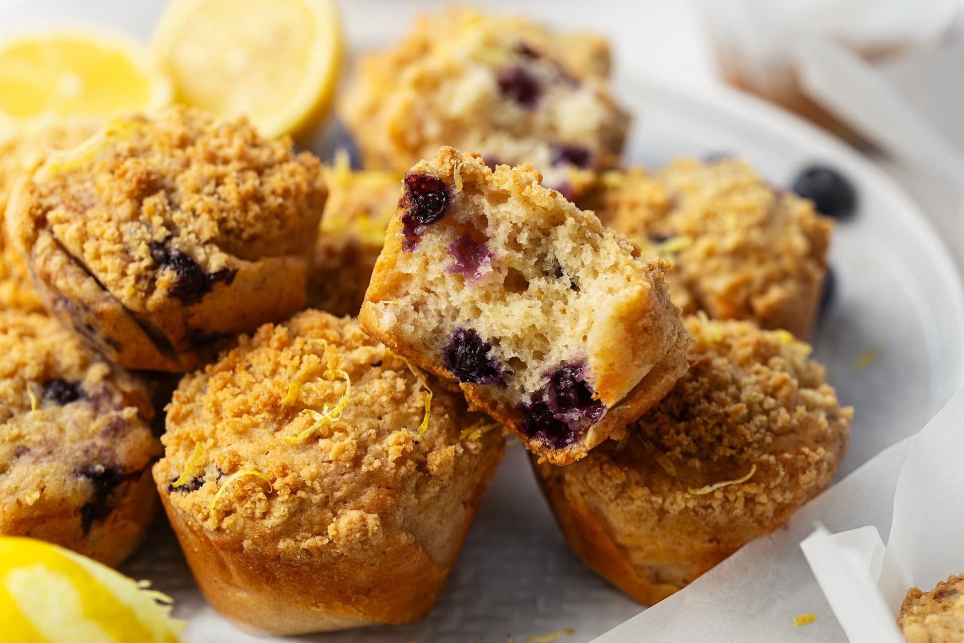 Lemon blueberry muffin cut in half, revealing a soft crumb with juicy blueberries inside.