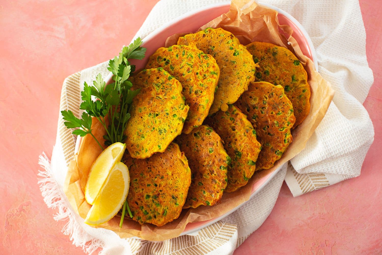 Pataniscas sem glúten com legumes verdes, acompanhadas por salsa e limão