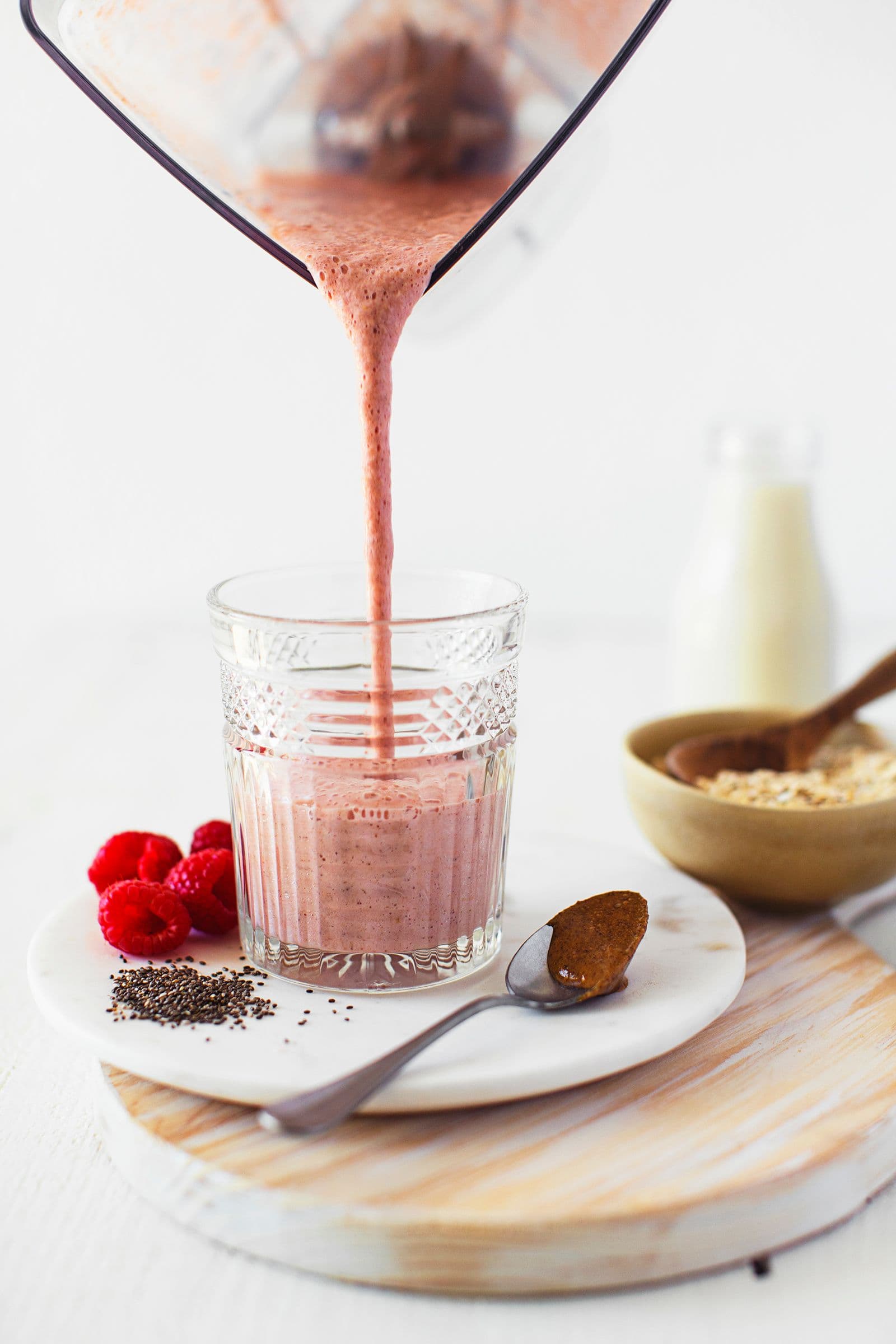 Batido cor-de-rosa acabado de triturar a ser vertido para um copo.