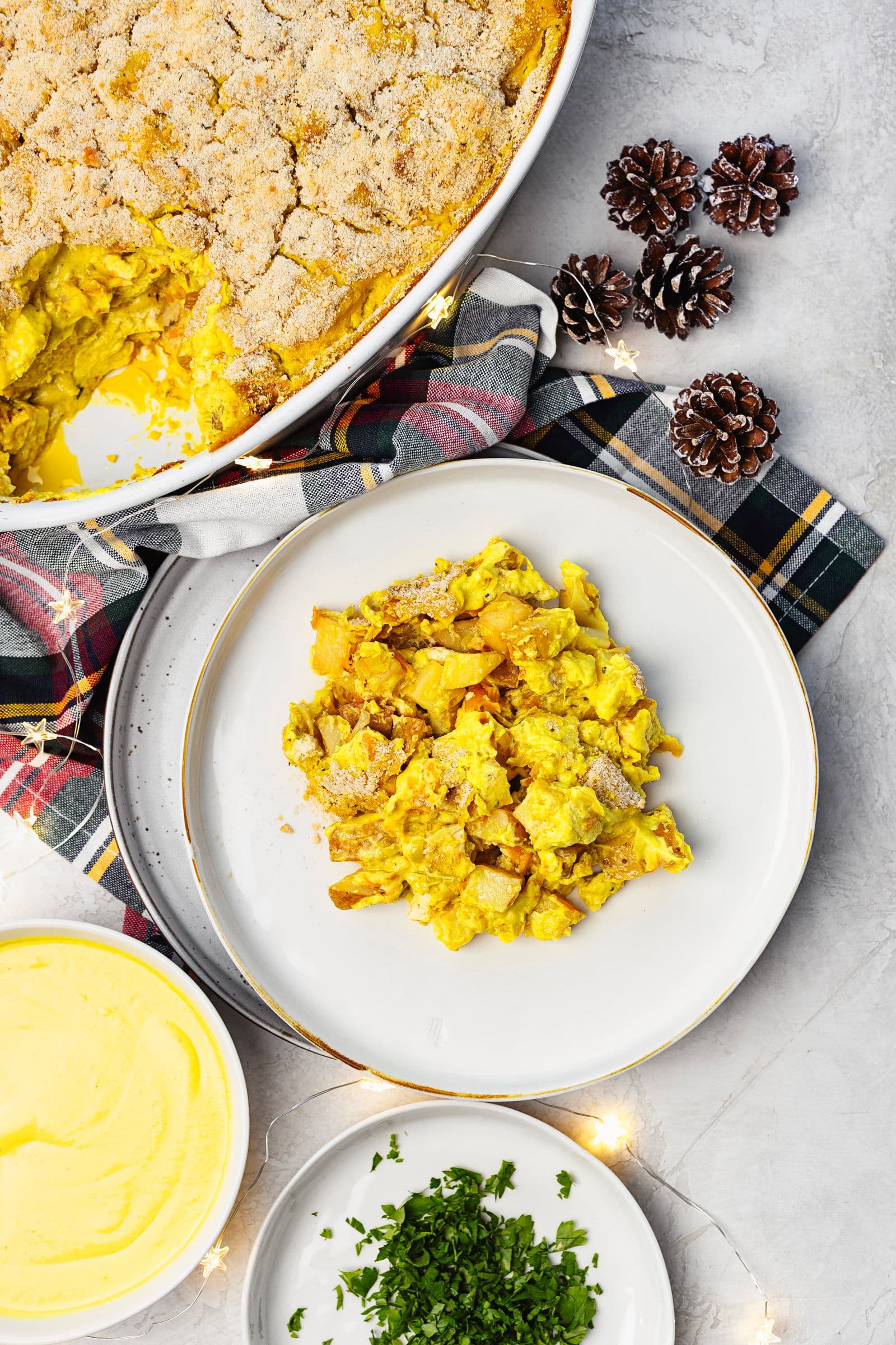 Travessa de gratinado com uma porção servida num prato, acompanhada de salsa e molho extra.